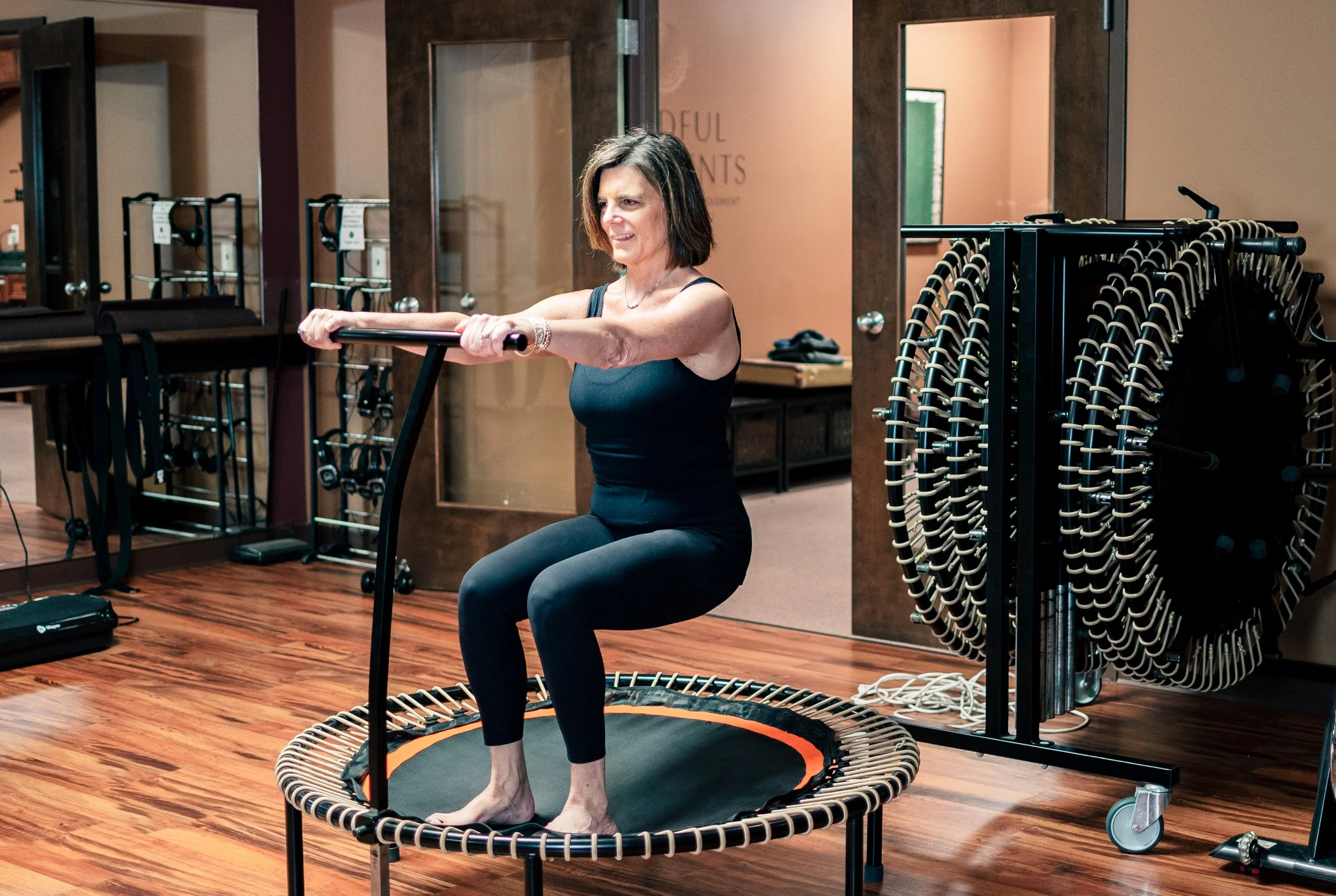 Rebecca Bell teaching a rebounding class featuring barre inspired exercise for strength, bone strength, cardiovascular health in Fort Wayne Indiana at Mindful Movements Pilates Studio