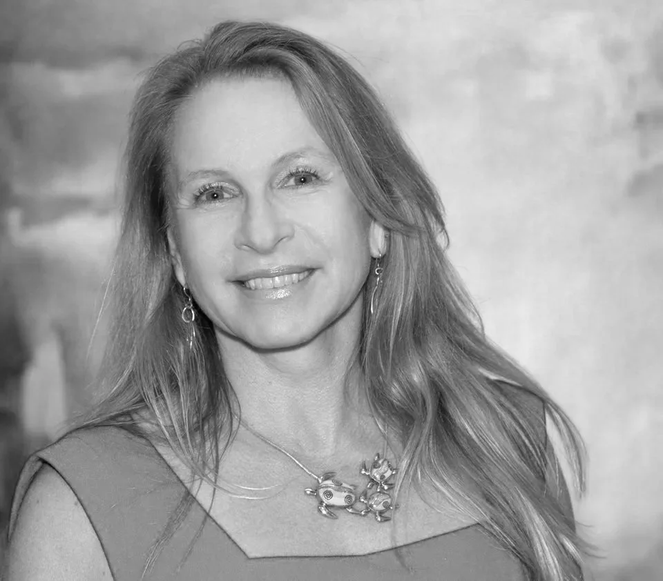 Vicki Nichols Goldstein smiling at the camera, wearing earrings and a necklace.