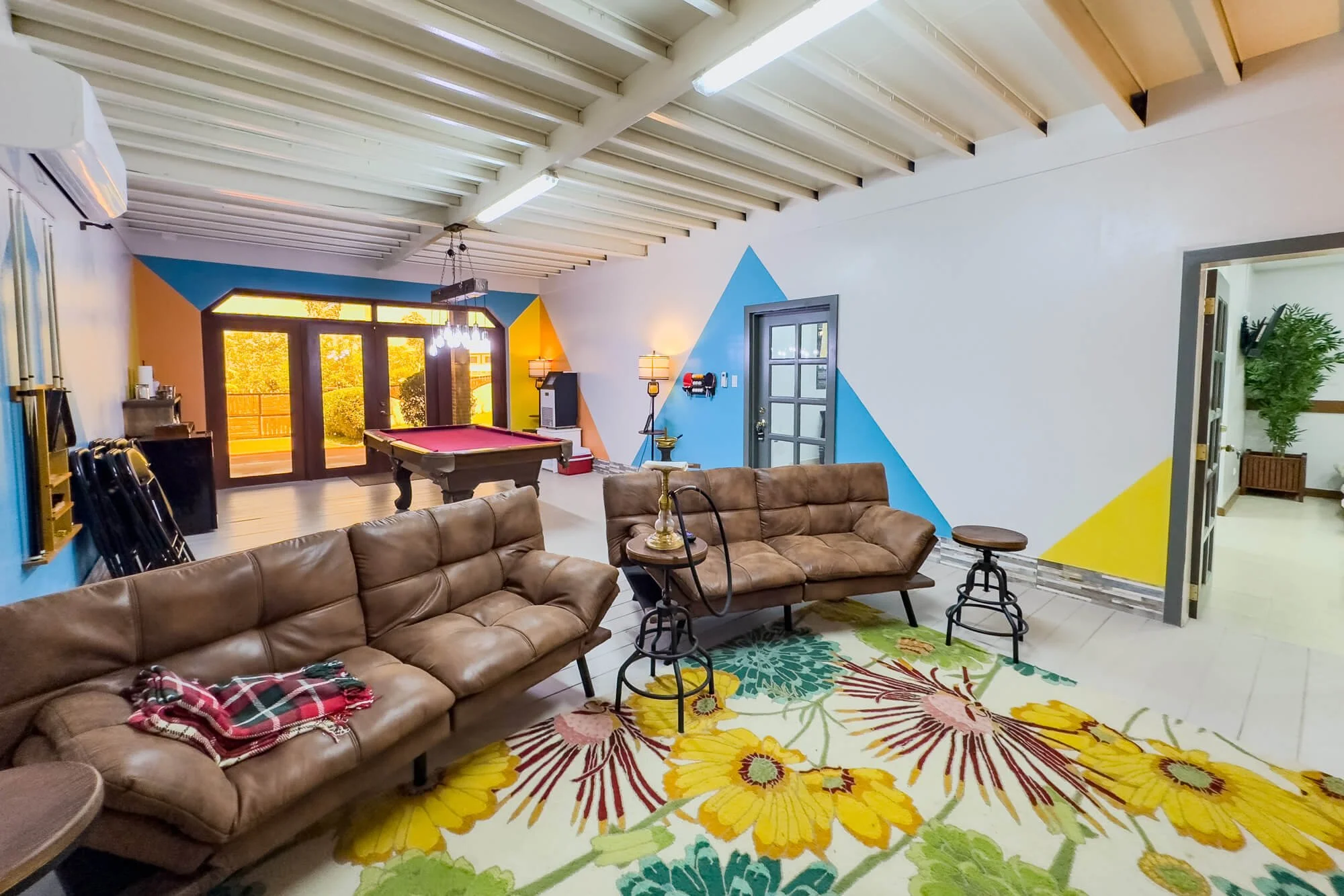 Entertainment room at Cayo Mountain View Estate with comfortable seating, pool table, colorful décor and direct access to an outdoor terrace.