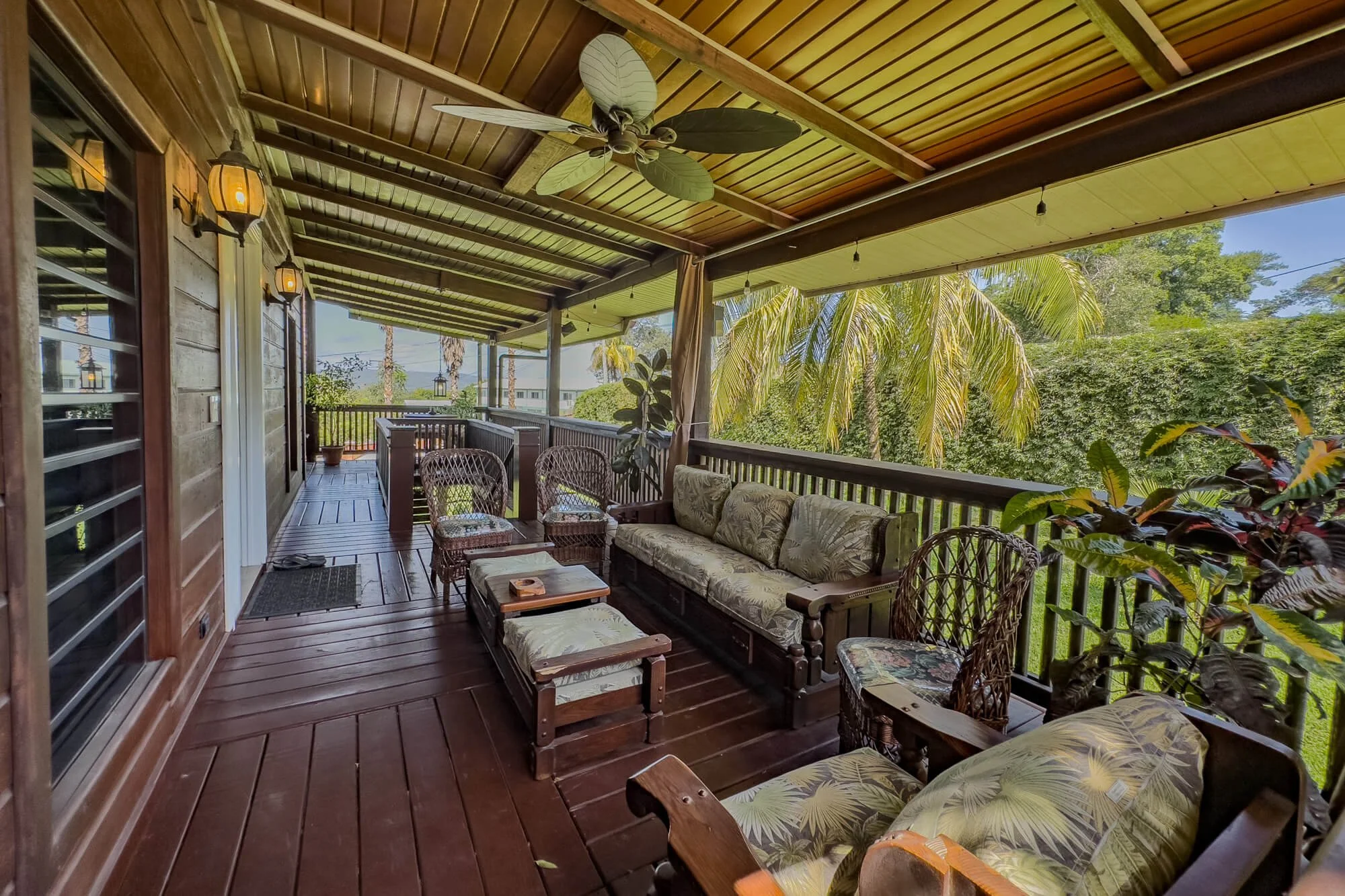 Covered wraparound verandah with comfortable outdoor seating overlooking the tropical gardens at Cayo Mountain View Estate.