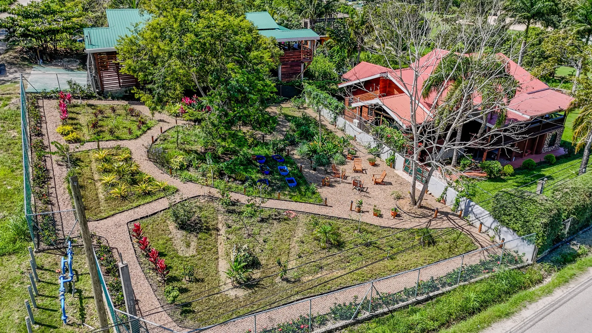Aerial view of Cayo Mountain View Estate in Santa Elena, Cayo District, Belize, showing the residence surrounded by landscaped tropical gardens.