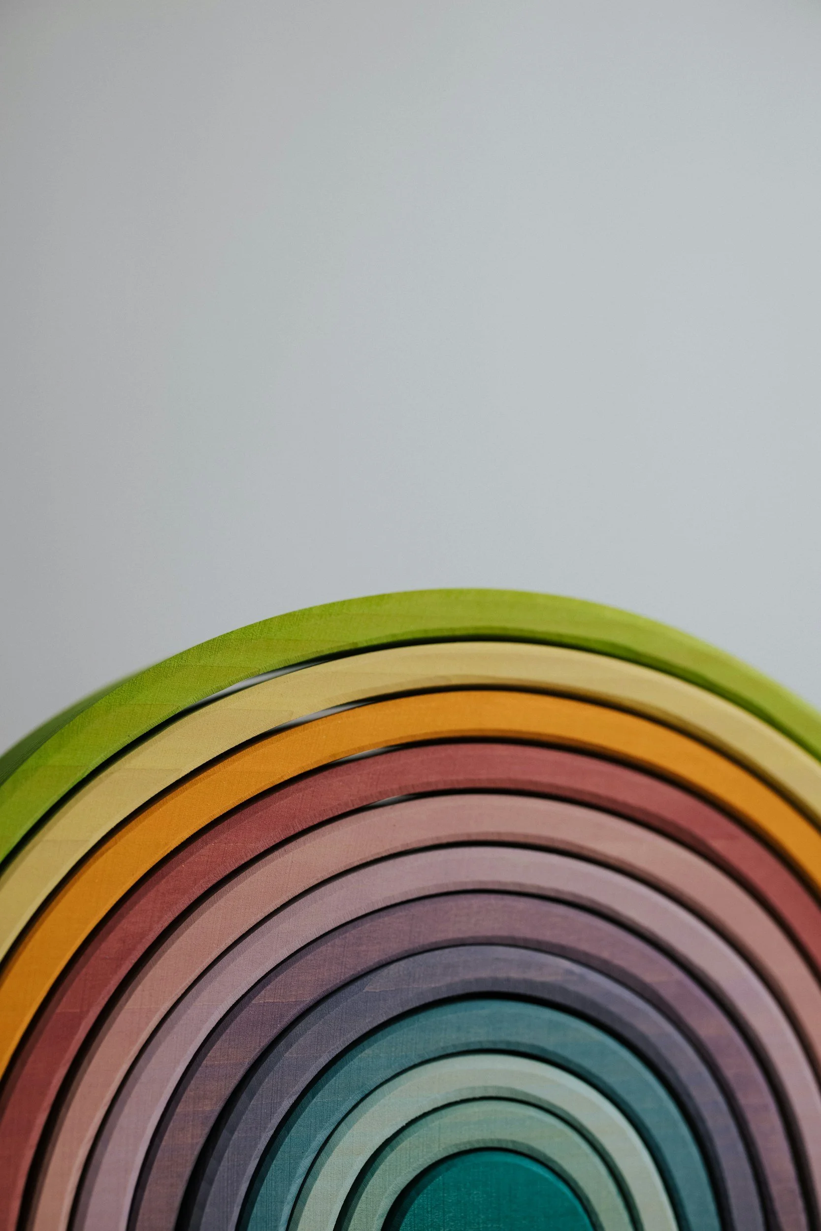 Colorful concentric circles forming a rainbow pattern, with a light grey background.