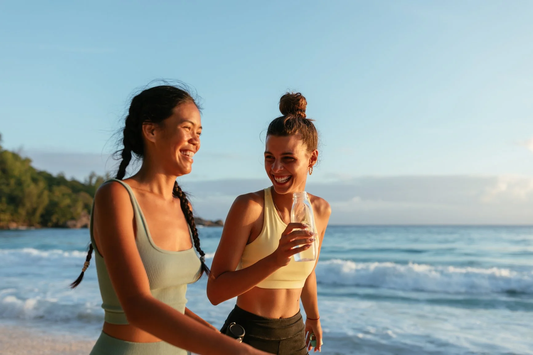 Two women running on the beach together at a girls getaway