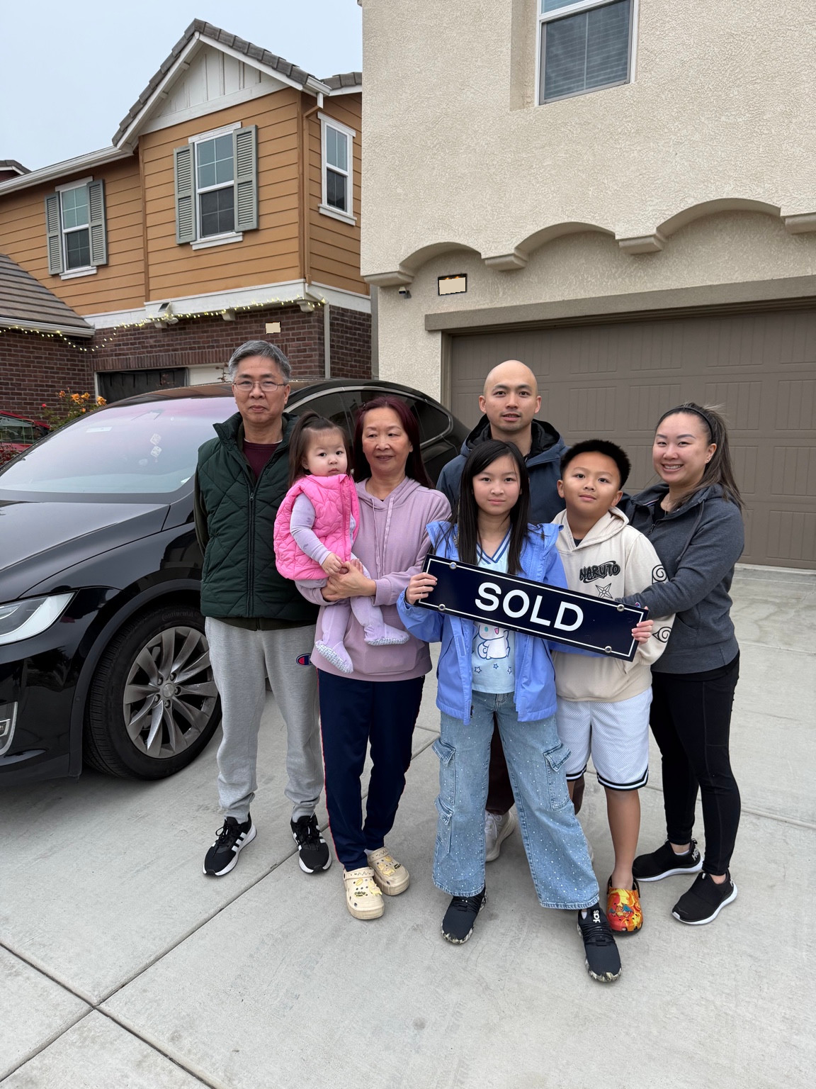 Ken and his family holding a SOLD sign before their move from California to Georgia.