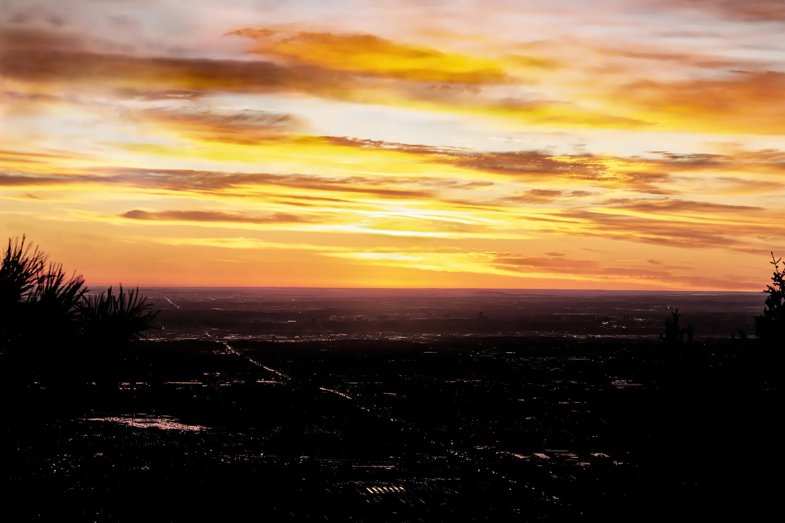 Denver Sunrise from Lookout Mountain - A brilliant sunrise ignites the sky above the Denver skyline as viewed from Lookout Mountain. Layers of golden clouds and silhouetted foothills create a dramatic start to the day along Colorado's Front Range.