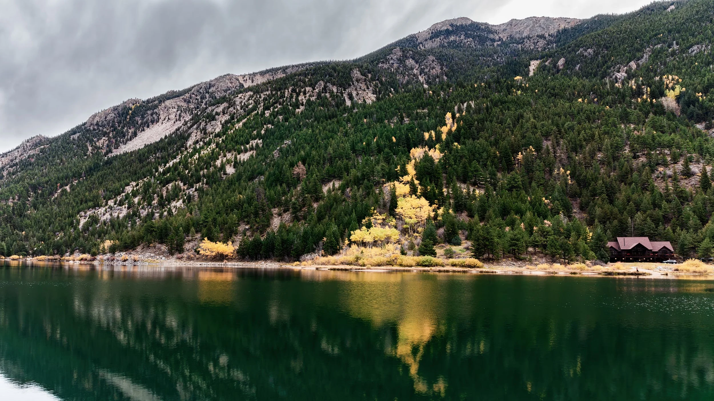 "Shoreline View from Georgetown Lake, Colorado"- A scenic shoreline view of Georgetown Lake in Colorado, featuring fall color, evergreen slopes, and calm mountain reflections.