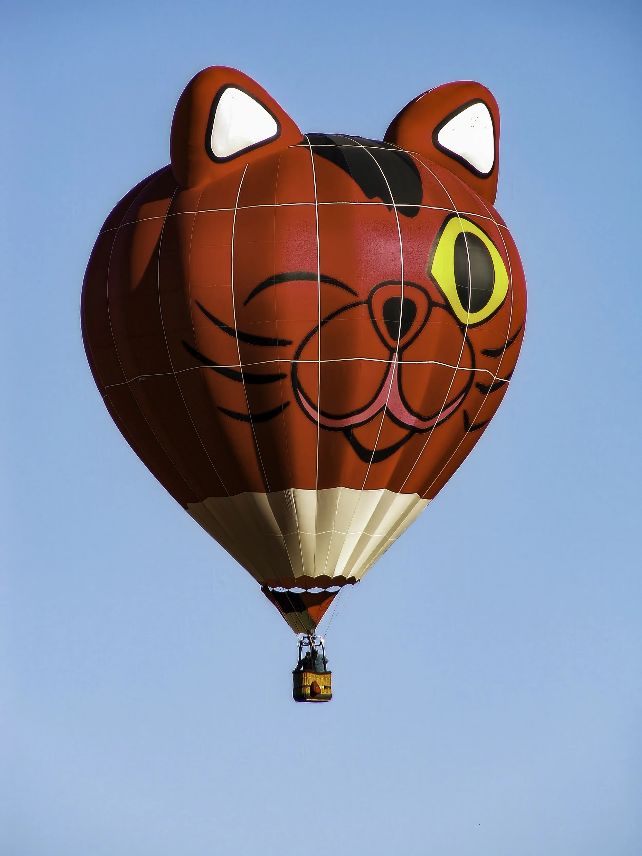 "Sky Whiskers – Cat Balloon at ColorFest, Pagosa Springs"- A red cat-shaped hot air balloon drifts through the clear Colorado sky during the annual ColorFest in Pagosa Springs.