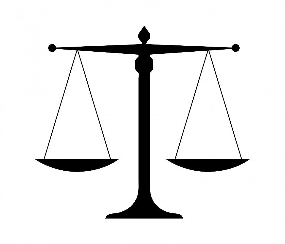 Black silhouette of a scale of justice against a white background.