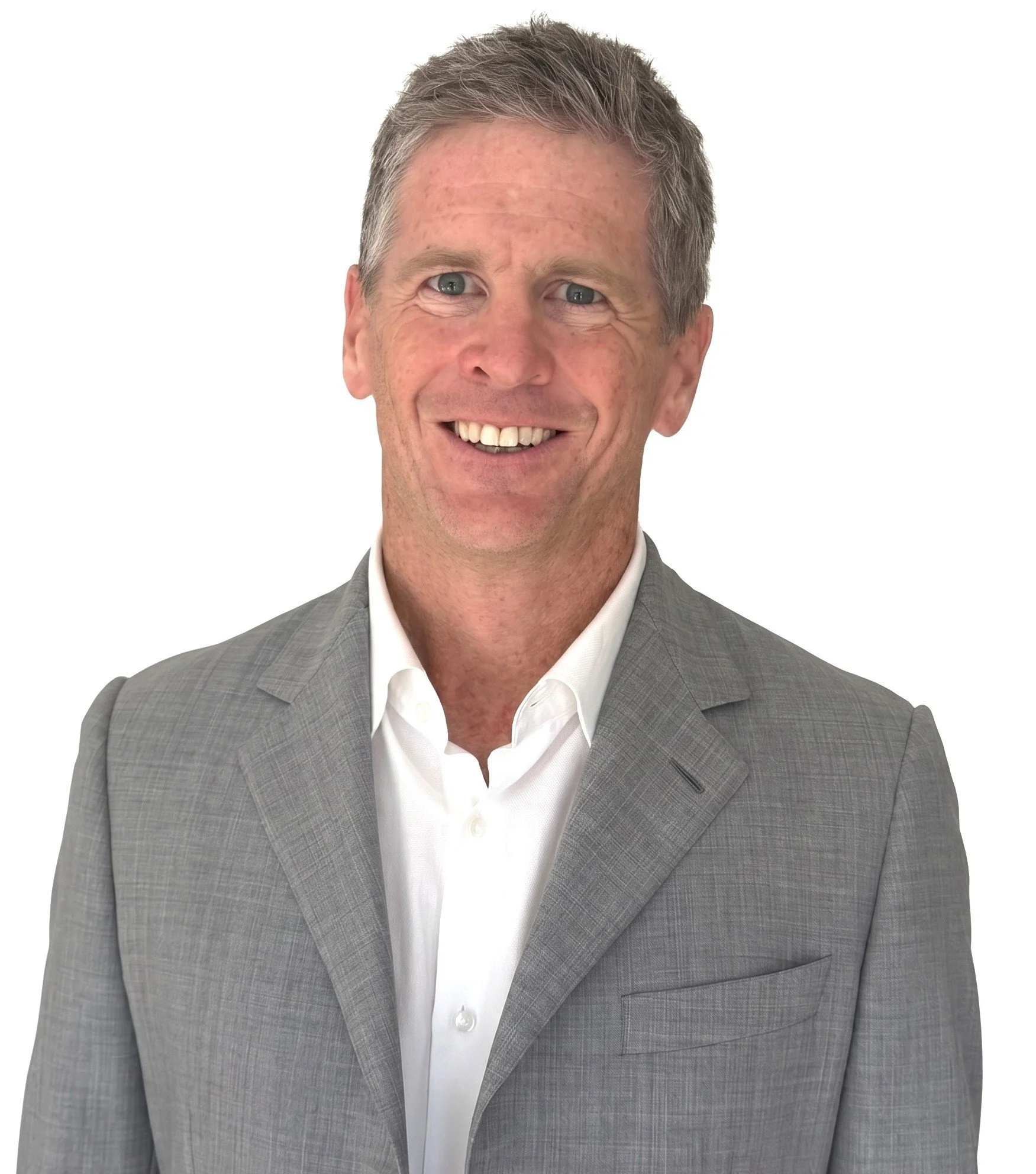 Close-up of a man with short gray hair wearing a gray suit jacket and white dress shirt, smiling against a plain white background.