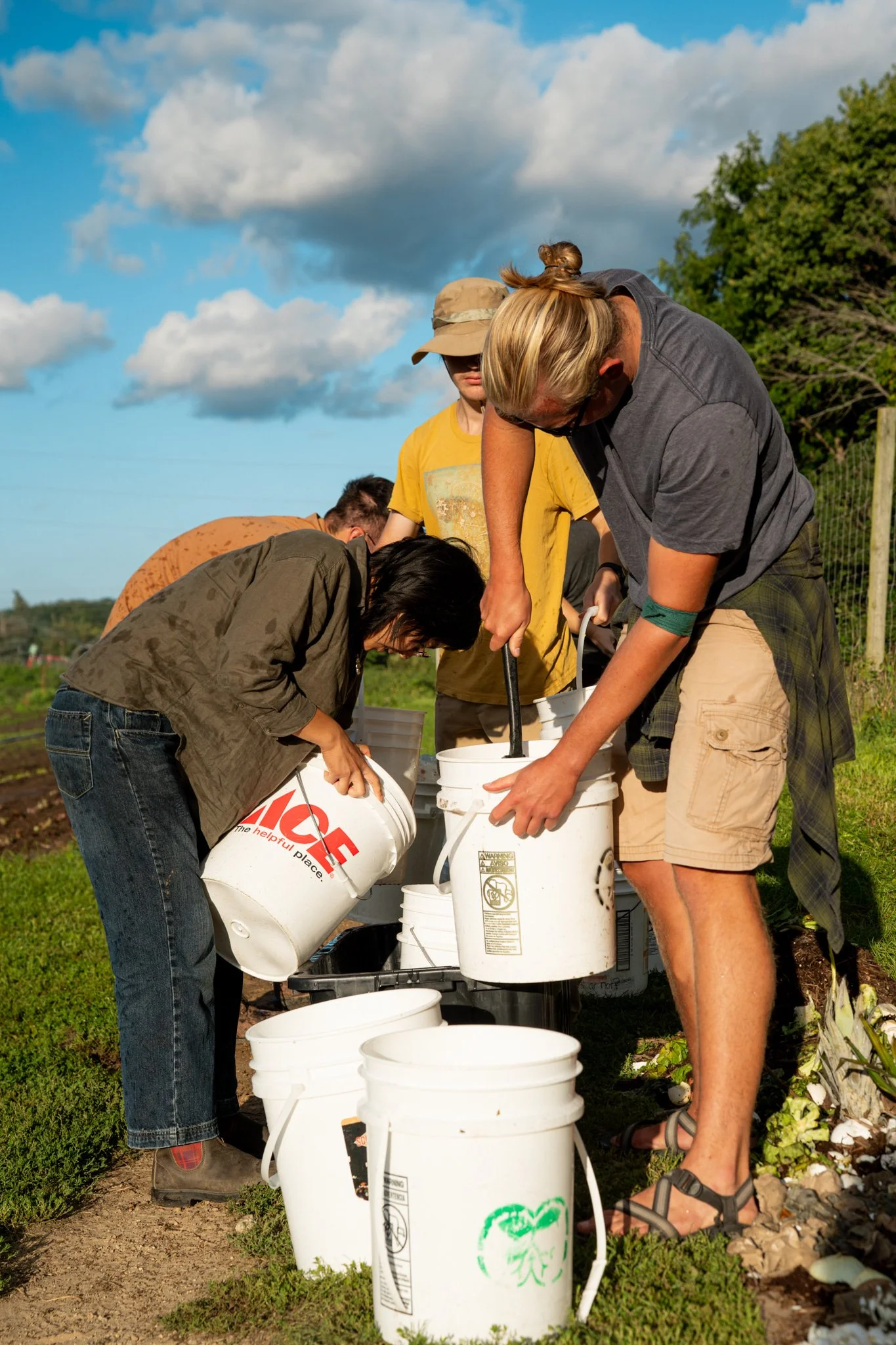 Participants empty and clean food-scrap buckets during Brainplate Grows’ Compost Olympics.