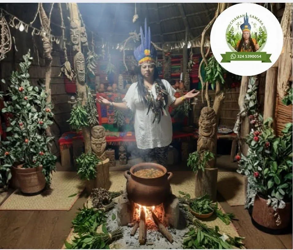 Una mujer vestida con ropa tradicional indígena, con un tocado de plumas, sostiene las manos extendidas en un entorno decorado con elementos culturales y vegetación, frente a una olla de barro sobre una fogata, en una ambientación que evoca una ceremonia ancestral.