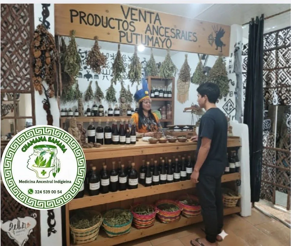 Persona comprando productos ancestrales en un puesto que ofrece productos de la cultura Putumayo, con hierbas y frascos en exhibición.