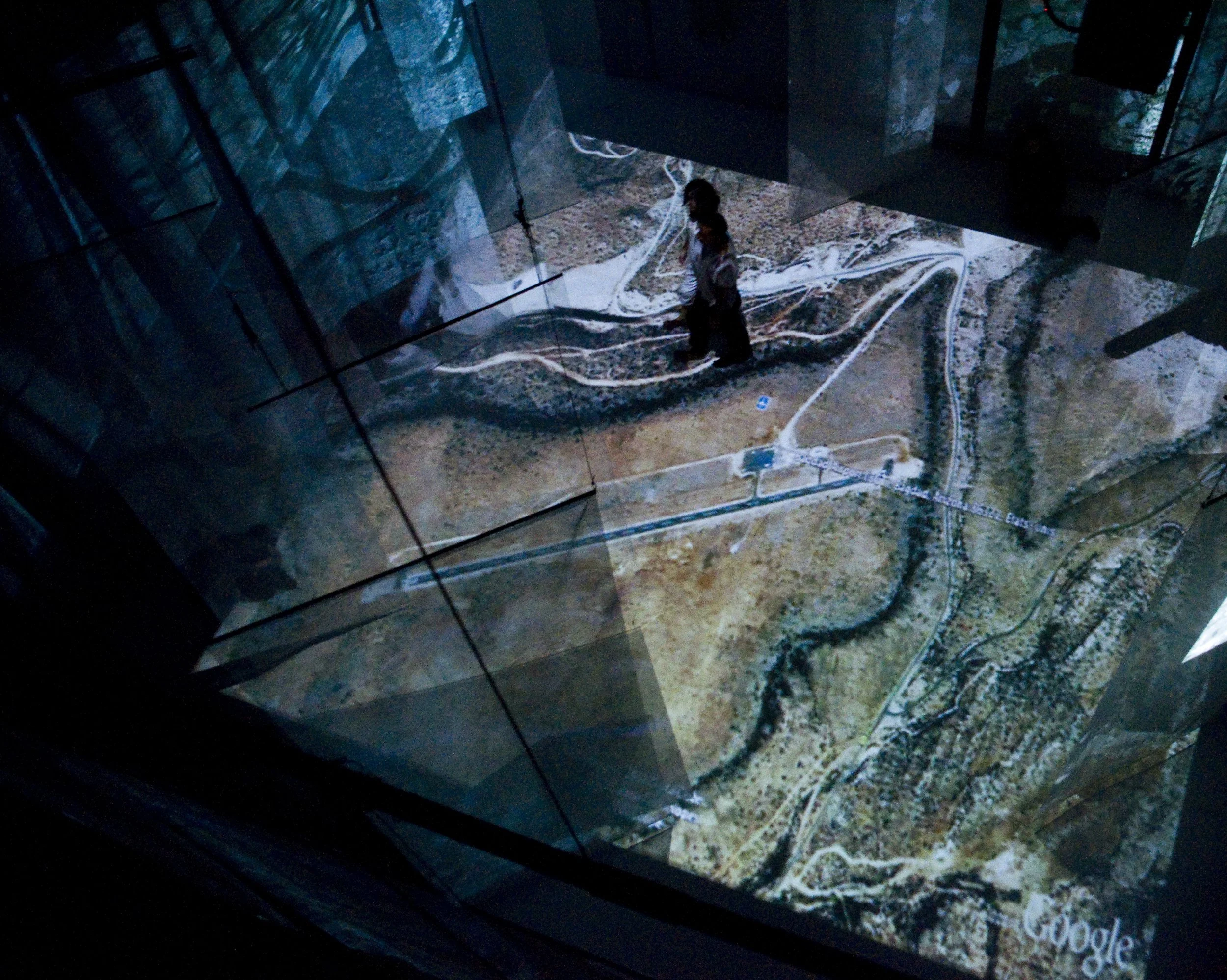 Bird's-eye view showing two dancers from the choreographed piece “Full Frame,” with a map projected onto the floor