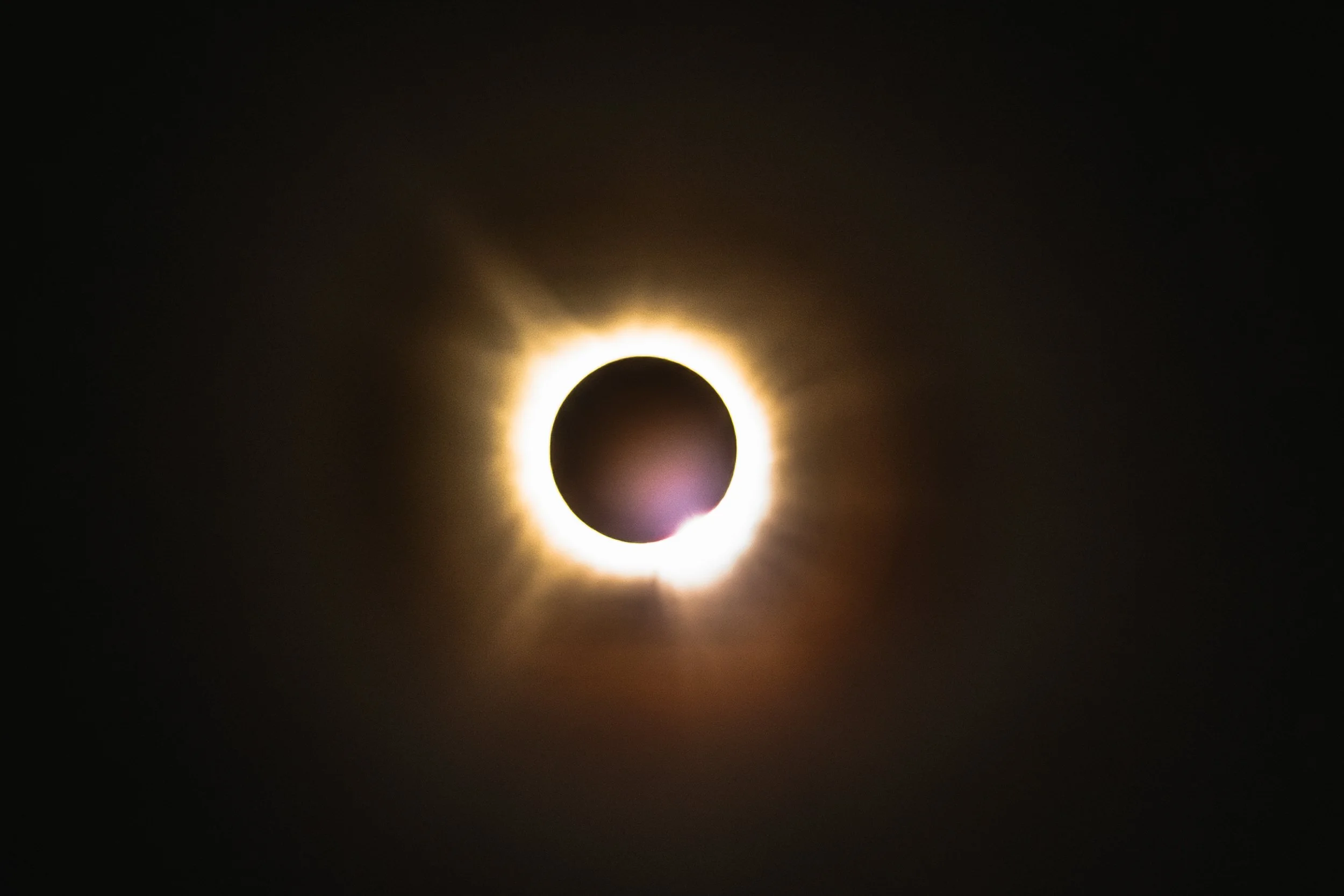 A solar eclipse showing the moon covering the sun, creating a glowing ring around the darkened sun.