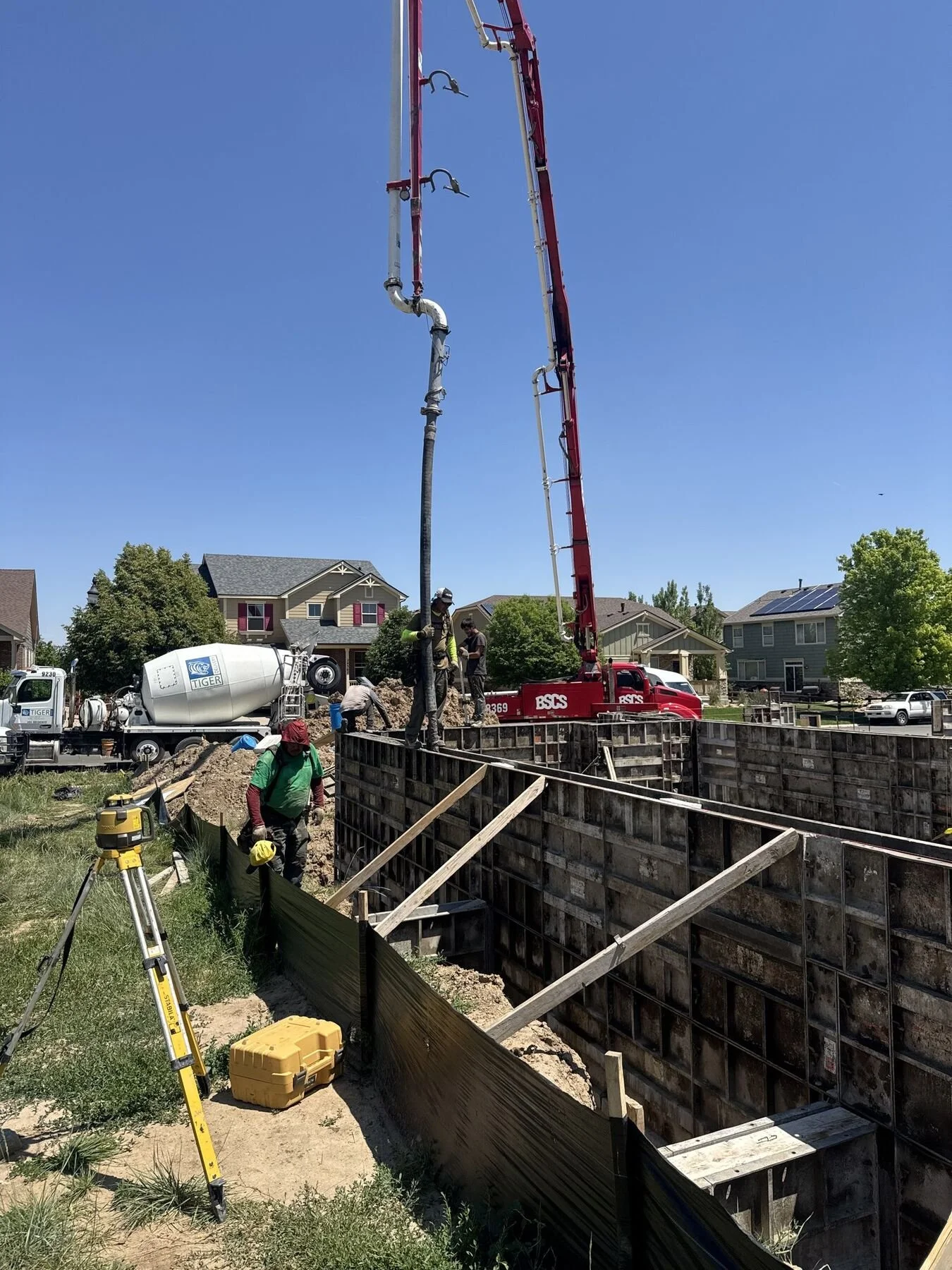 BSCS Pumping 38-meter boom pump placing concrete at a residential foundation pour with mixer truck