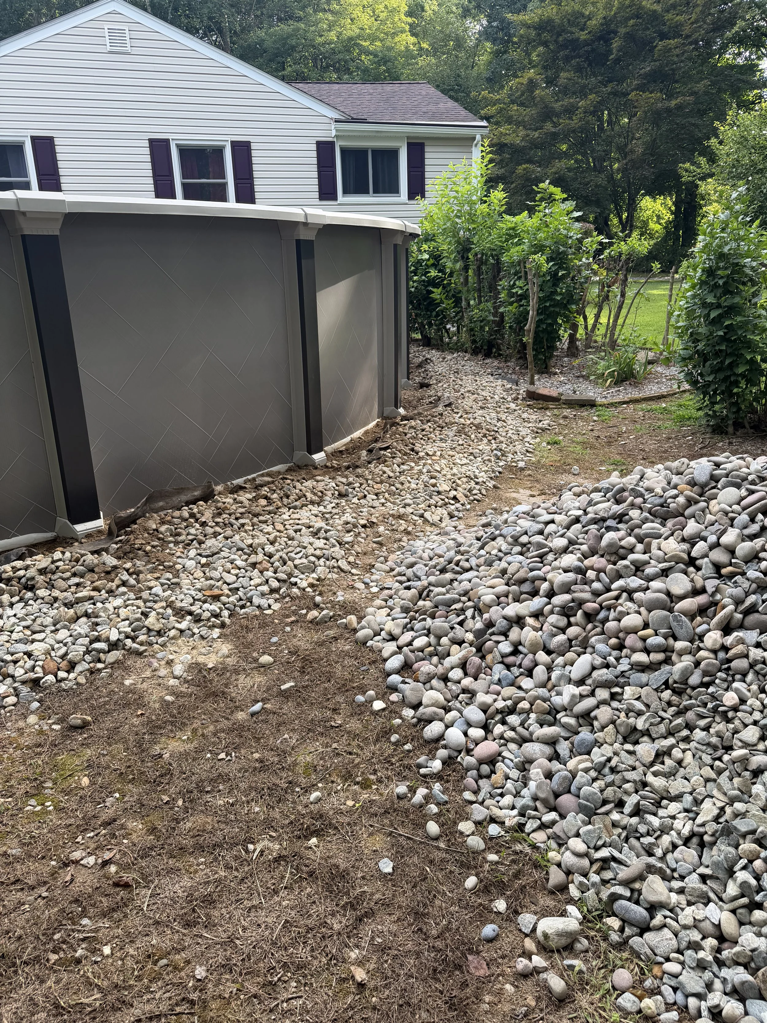 Repair, regrade, and new stone to fix a drainage issue underneath this pool. (Before) - Guilford, CT.