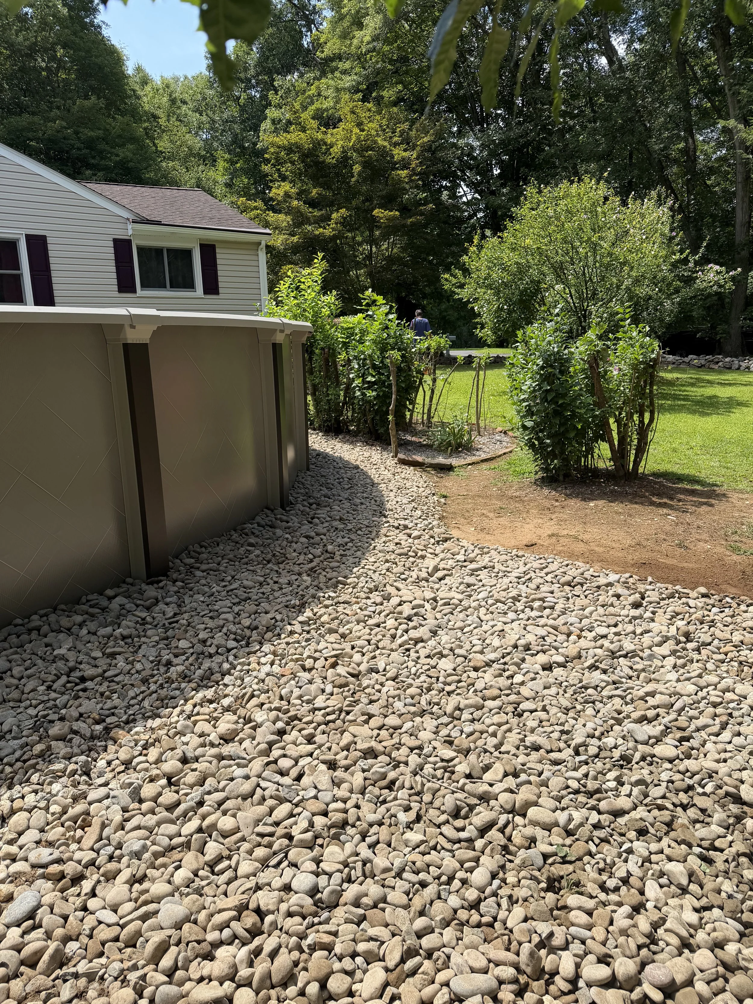Repair, regrade, and new stone to fix a drainage issue underneath this pool. (After) - Guilford, CT.