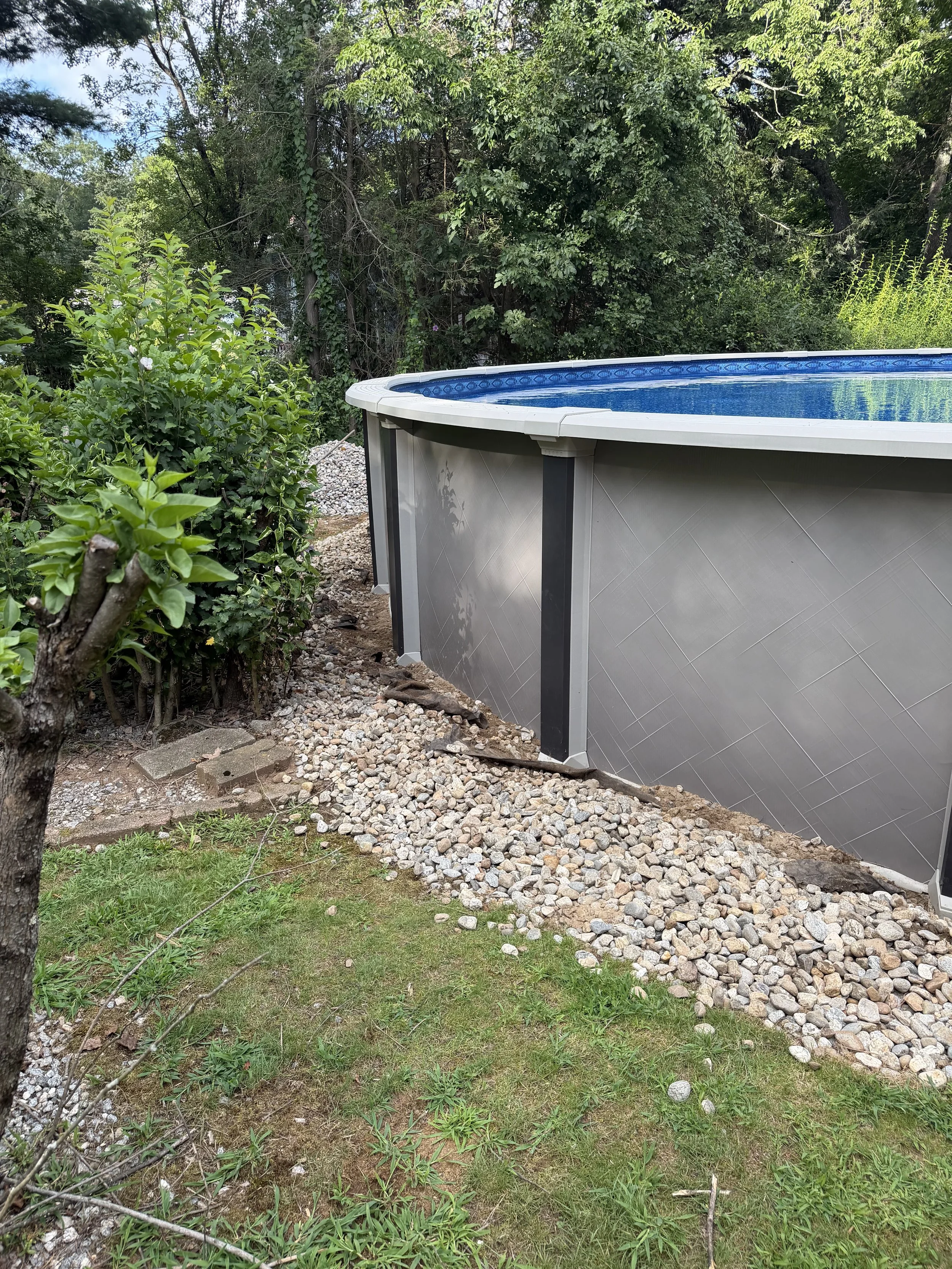 Repair, regrade, and new stone to fix a drainage issue underneath this pool. (Before) - Guilford, CT.