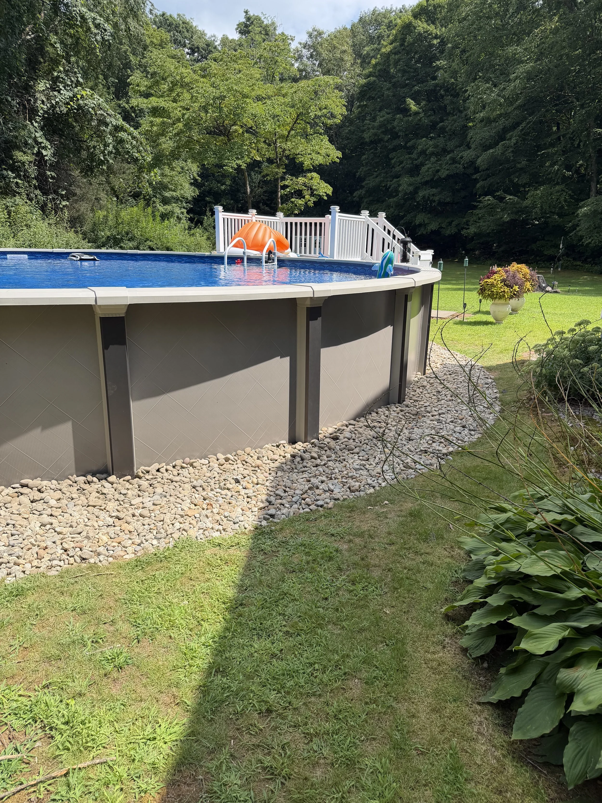 Repair, regrade, and new stone to fix a drainage issue underneath this pool. (After) - Guilford, CT.