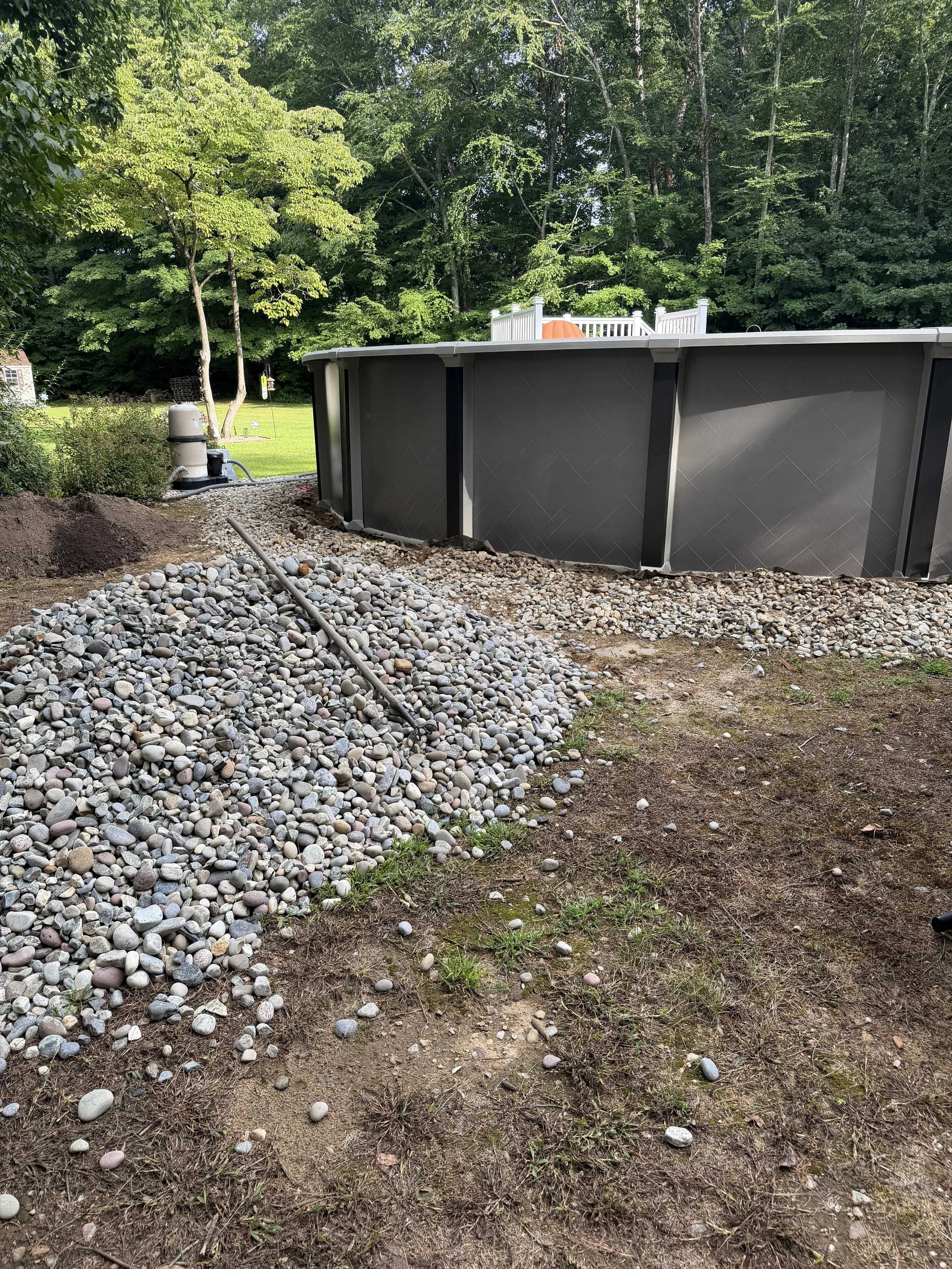 Repair, regrade, and new stone to fix a drainage issue underneath this pool. (Before) - Guilford, CT.