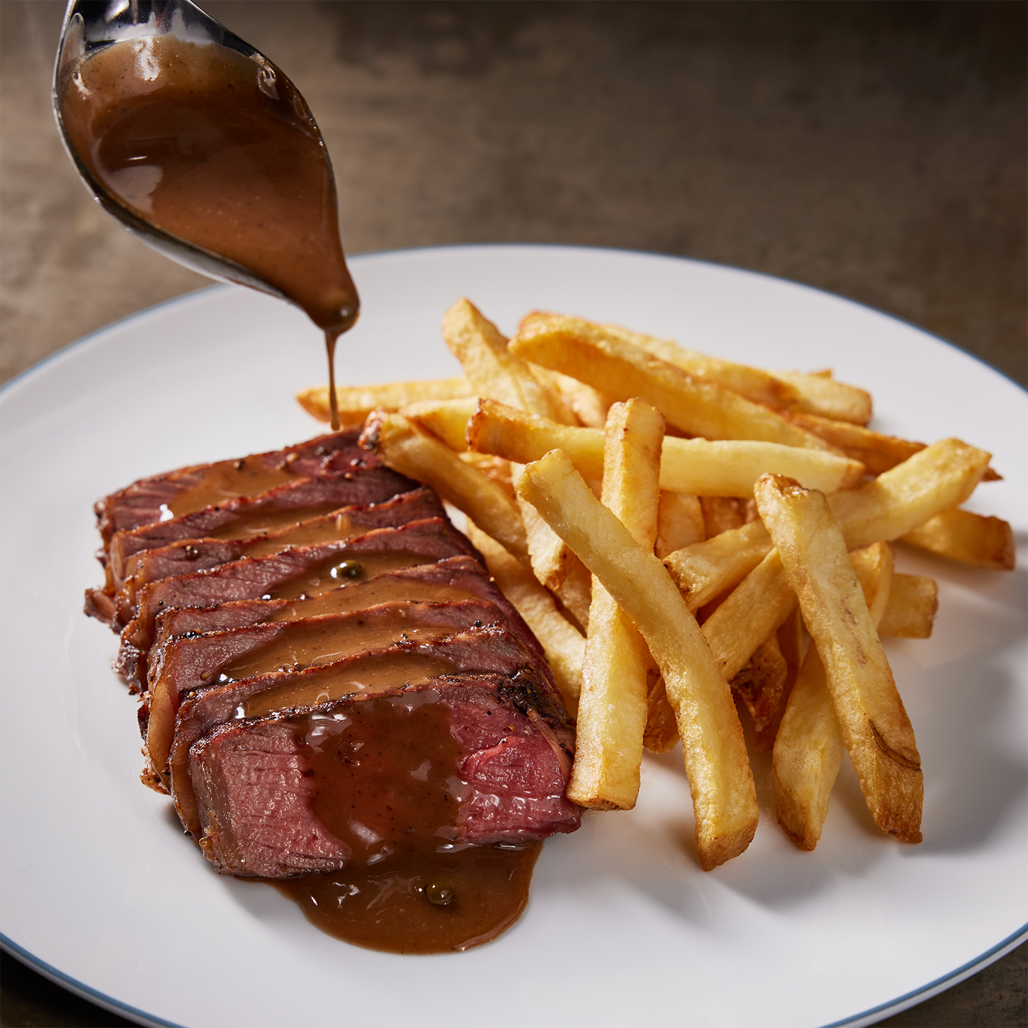 Petite Hanger steak with brown gravy and French fries.