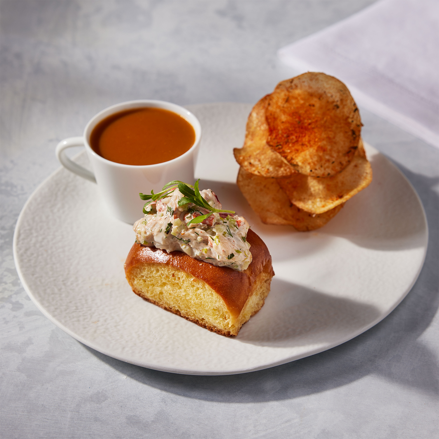 California-style mini lobster roll with dipping sauce and spiced chips.