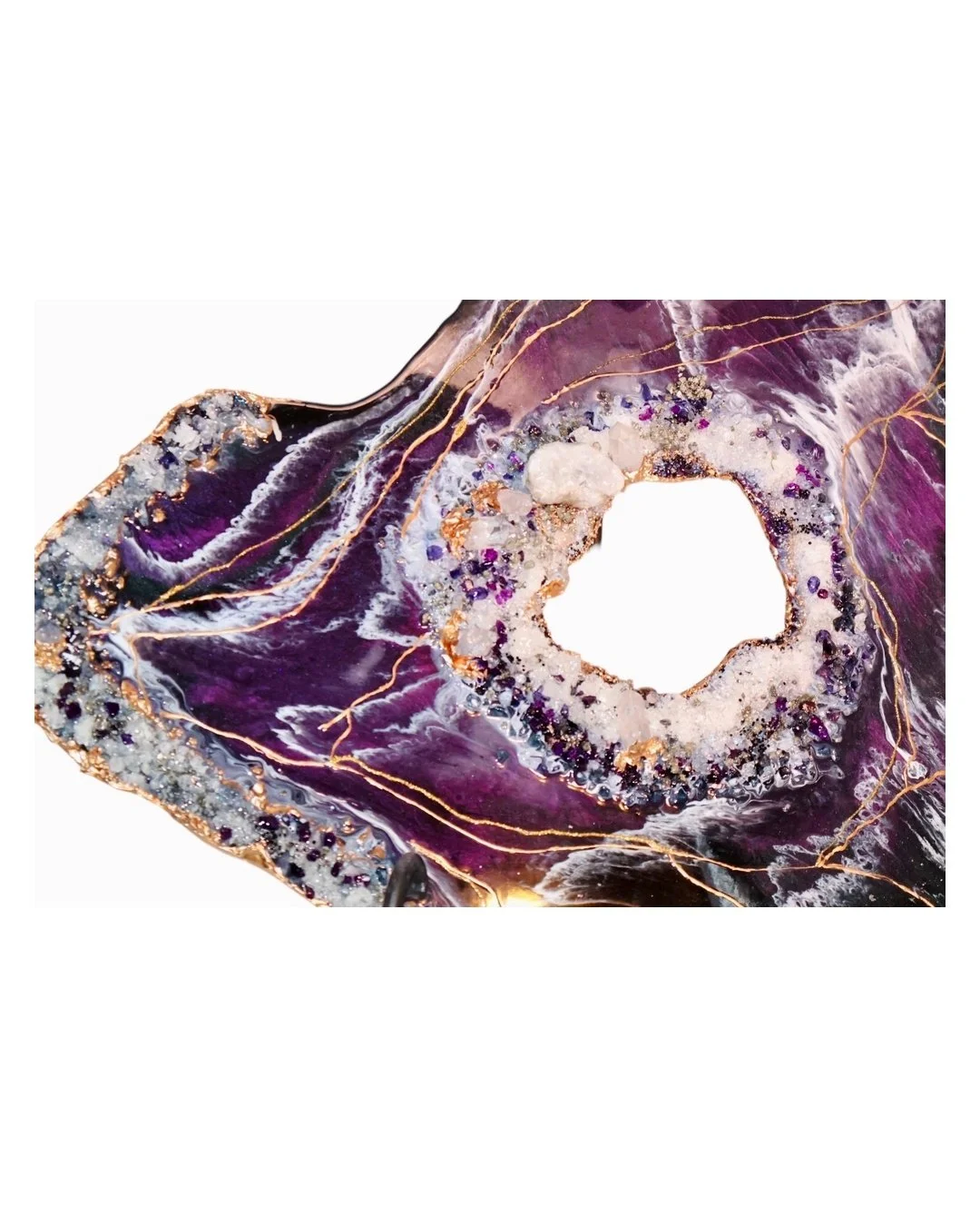 A close-up of a purple and gold geode, showing its crystalline interior and intricate patterns.