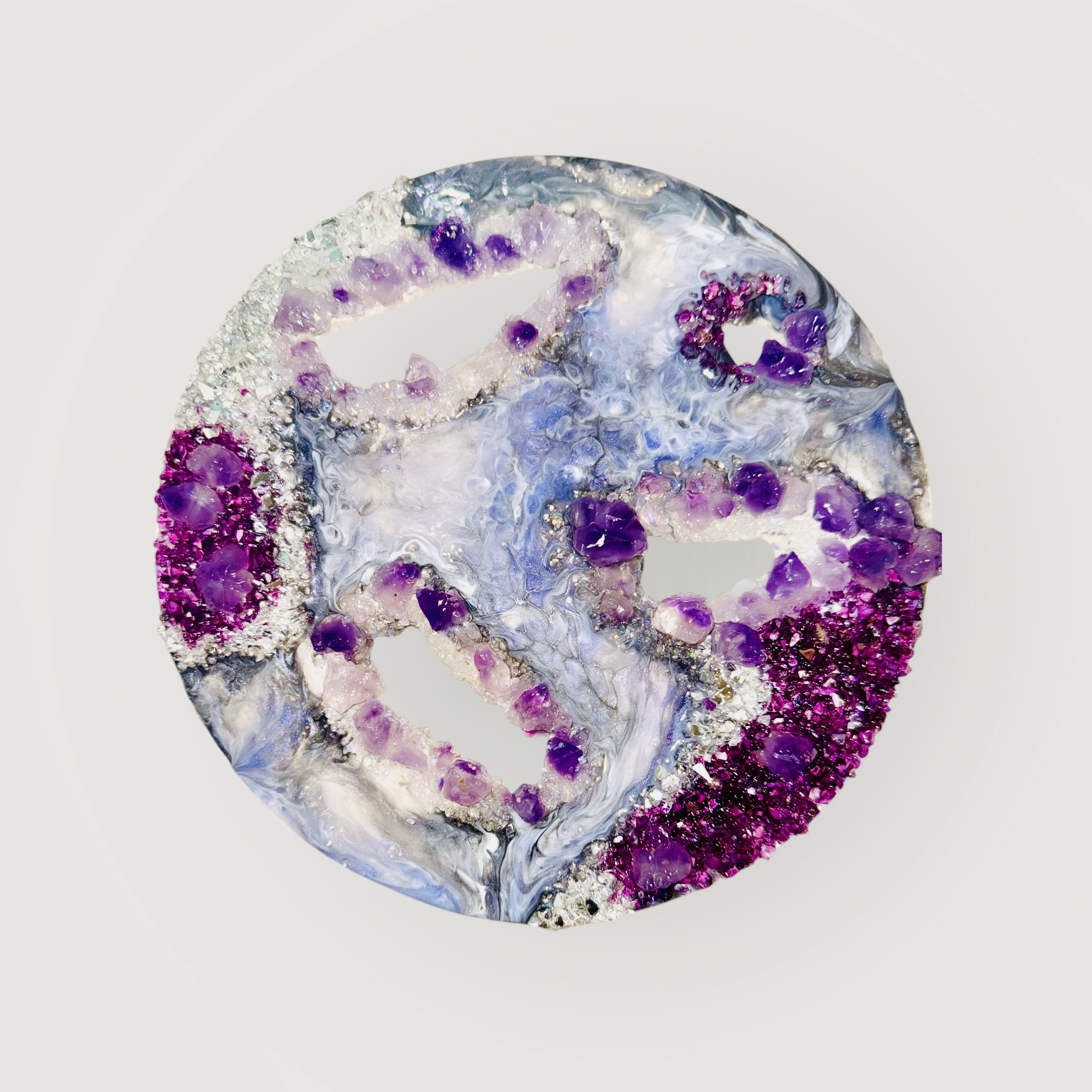 A colorful geode with purple, pink, and white crystals inside, with a glossy, swirling exterior, displayed against a plain white background.