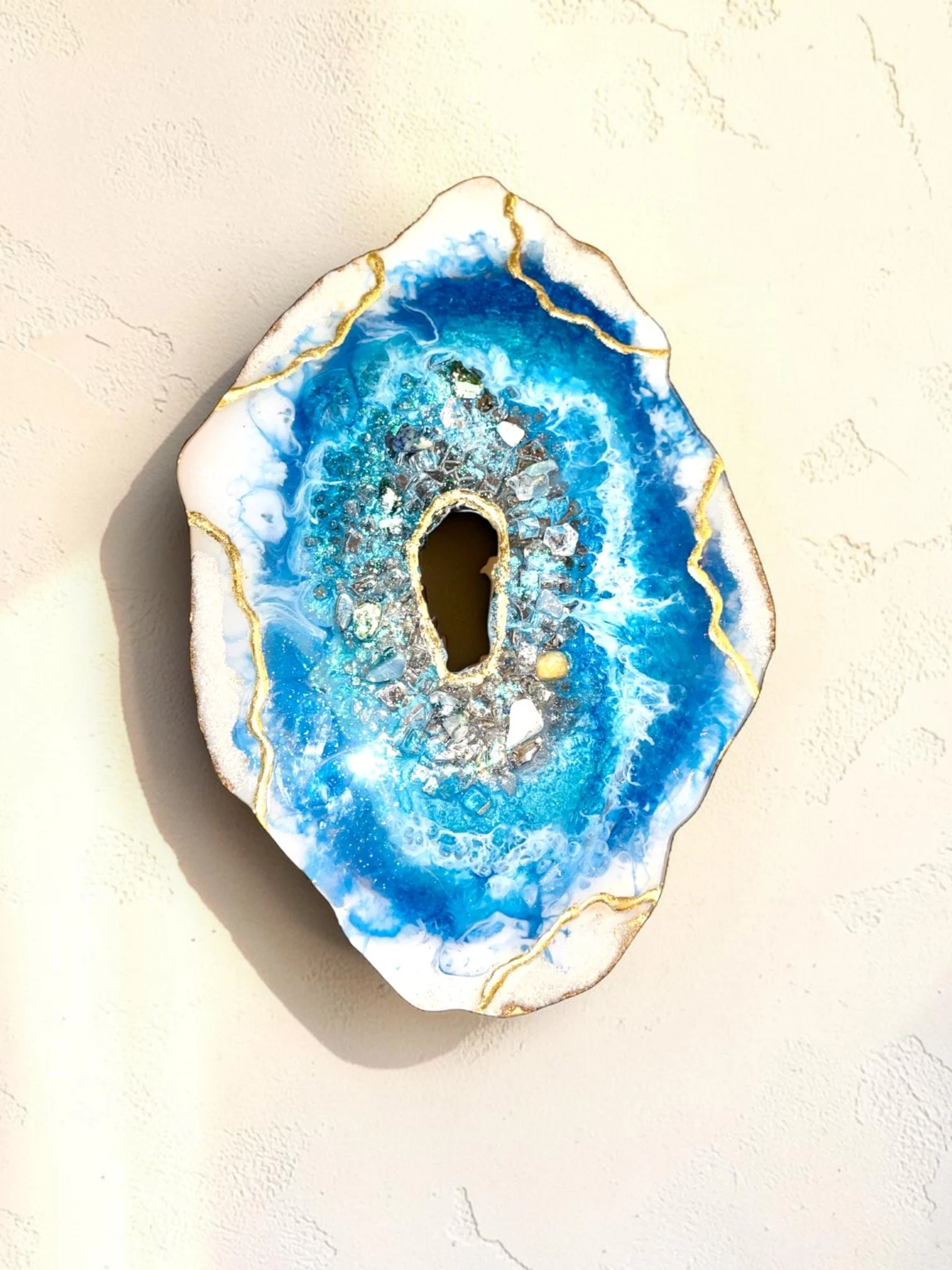 Blue and white resin geode wall decor with gold accents and crystal embellishments.