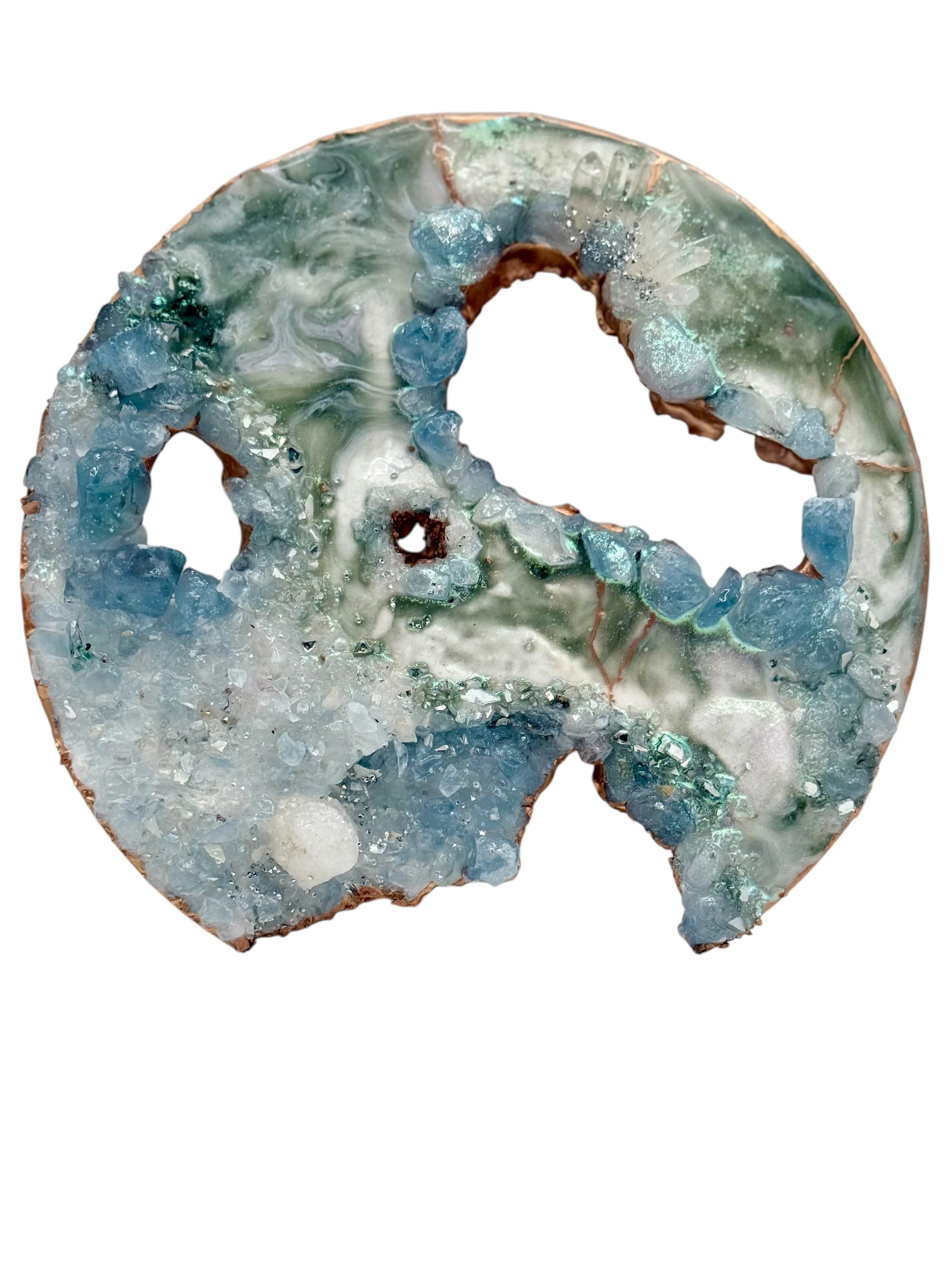 Close-up of a polished slice of blue and green agate with crystalline formations along the edges.