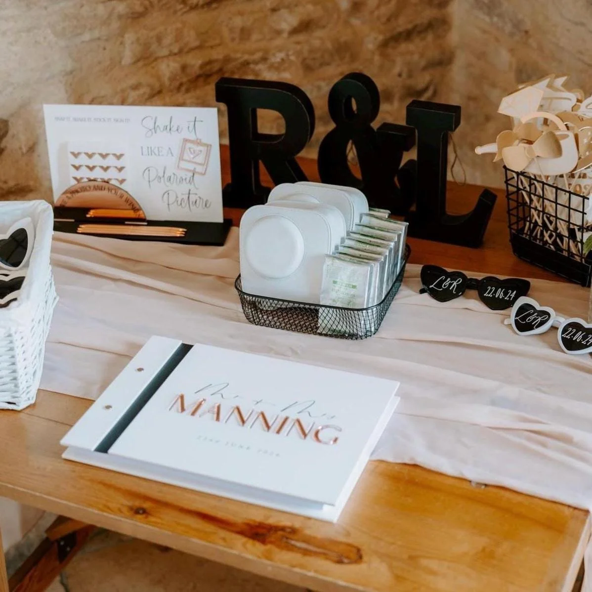 Personalised acrylic wedding guestbook displayed with an instant camera and matching Polaroid instruction sign