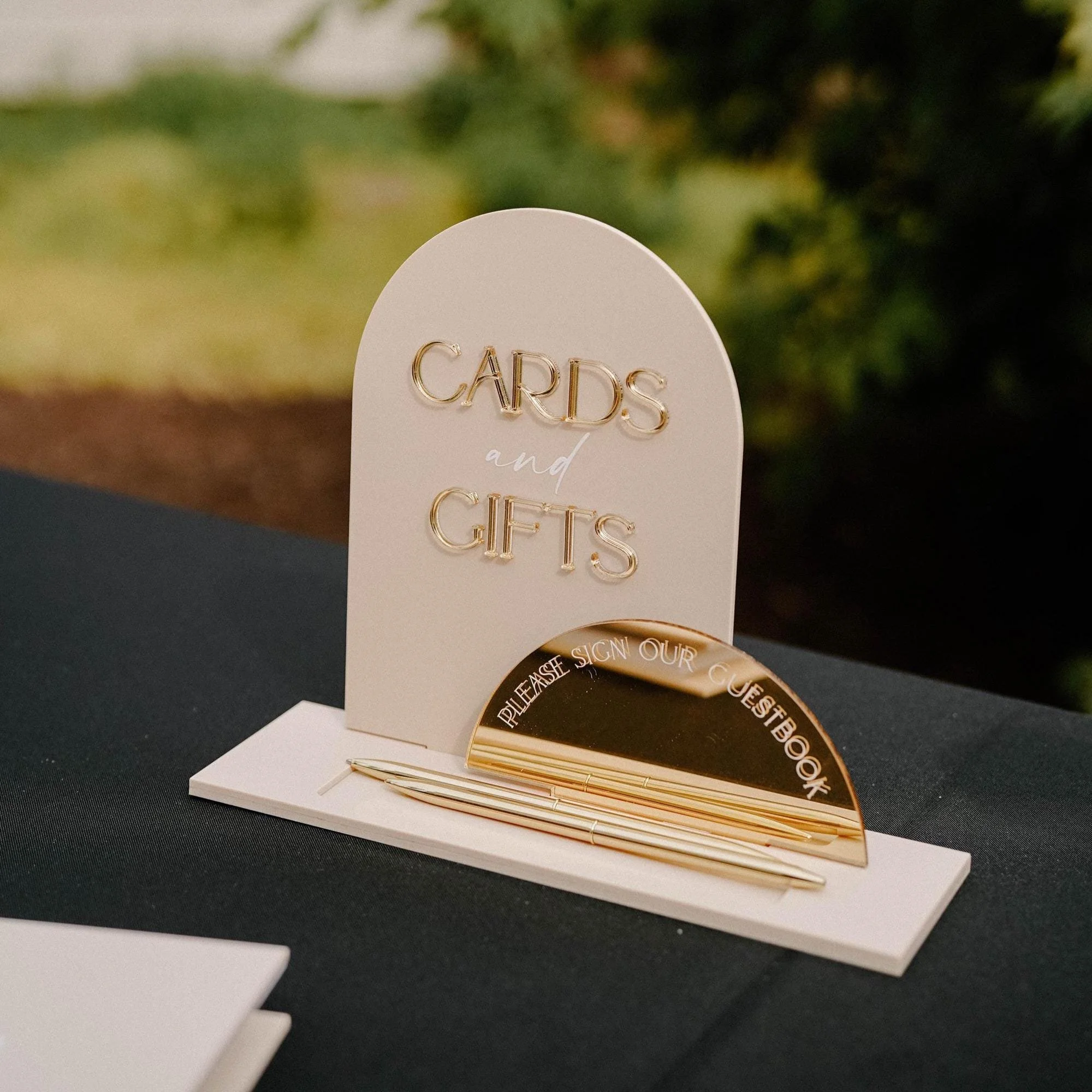Oyster acrylic Cards and Gifts dome wedding sign with a matching guestbook sign and gold pens.