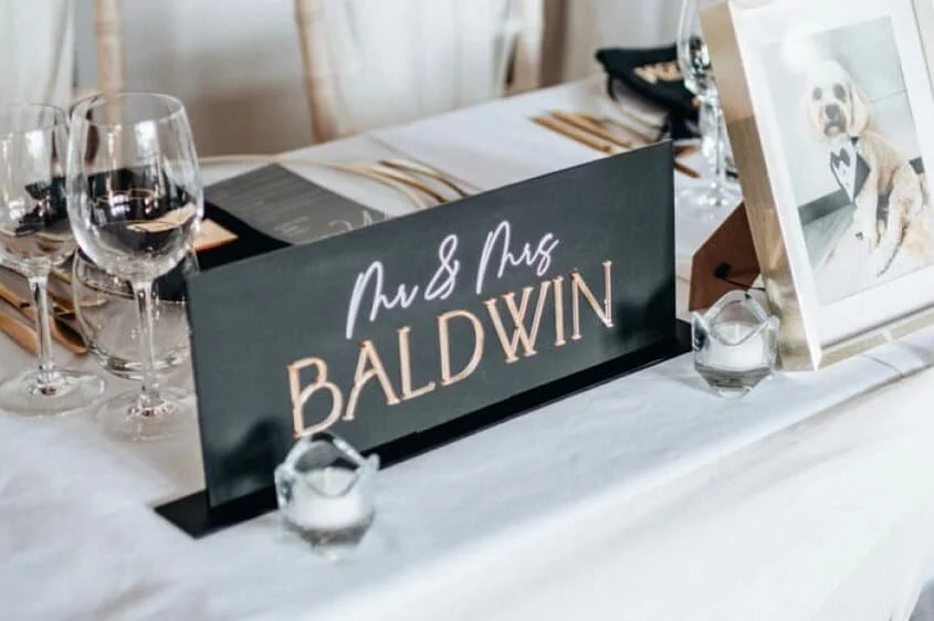 Black acrylic wedding top table sign with raised white Baldwin surname and matching base.