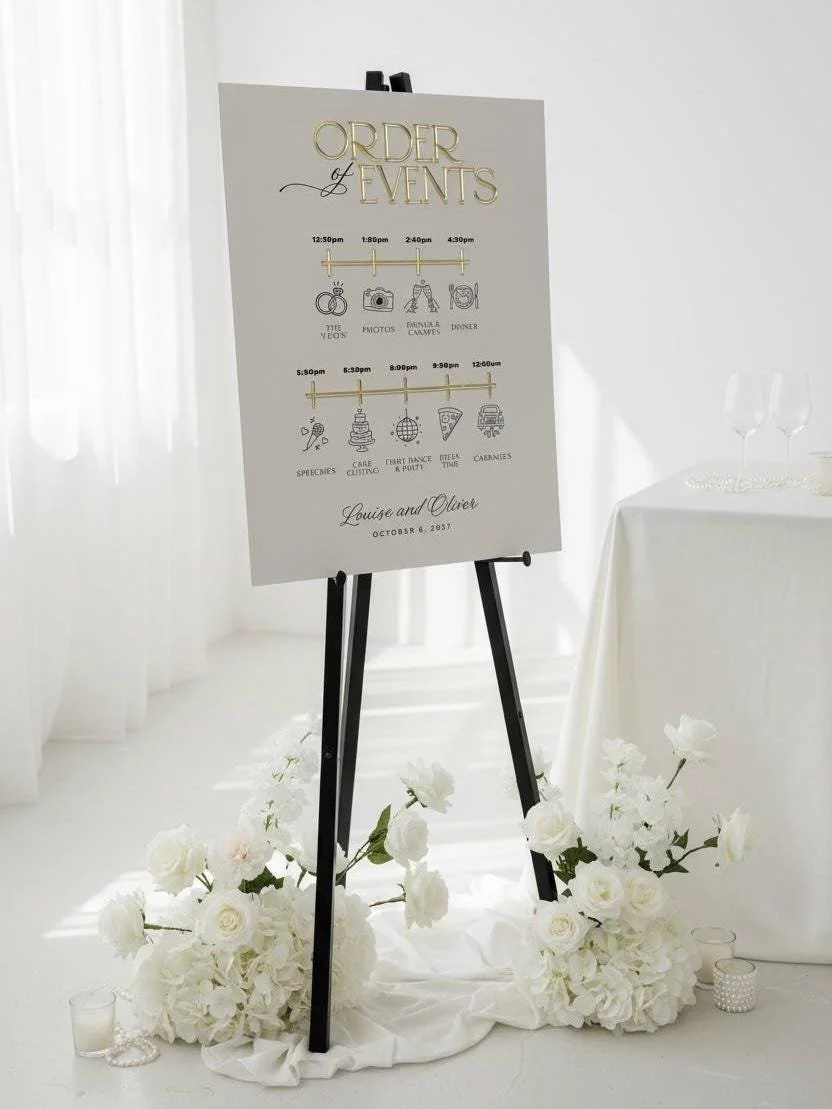 Large wedding Order of the Day sign displayed on a black easel