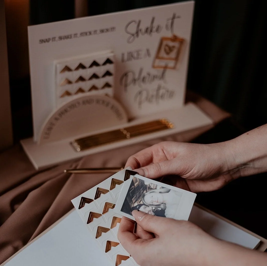 Instant photo guestbook accessories including an acrylic instruction sign, pens and photo corners.
