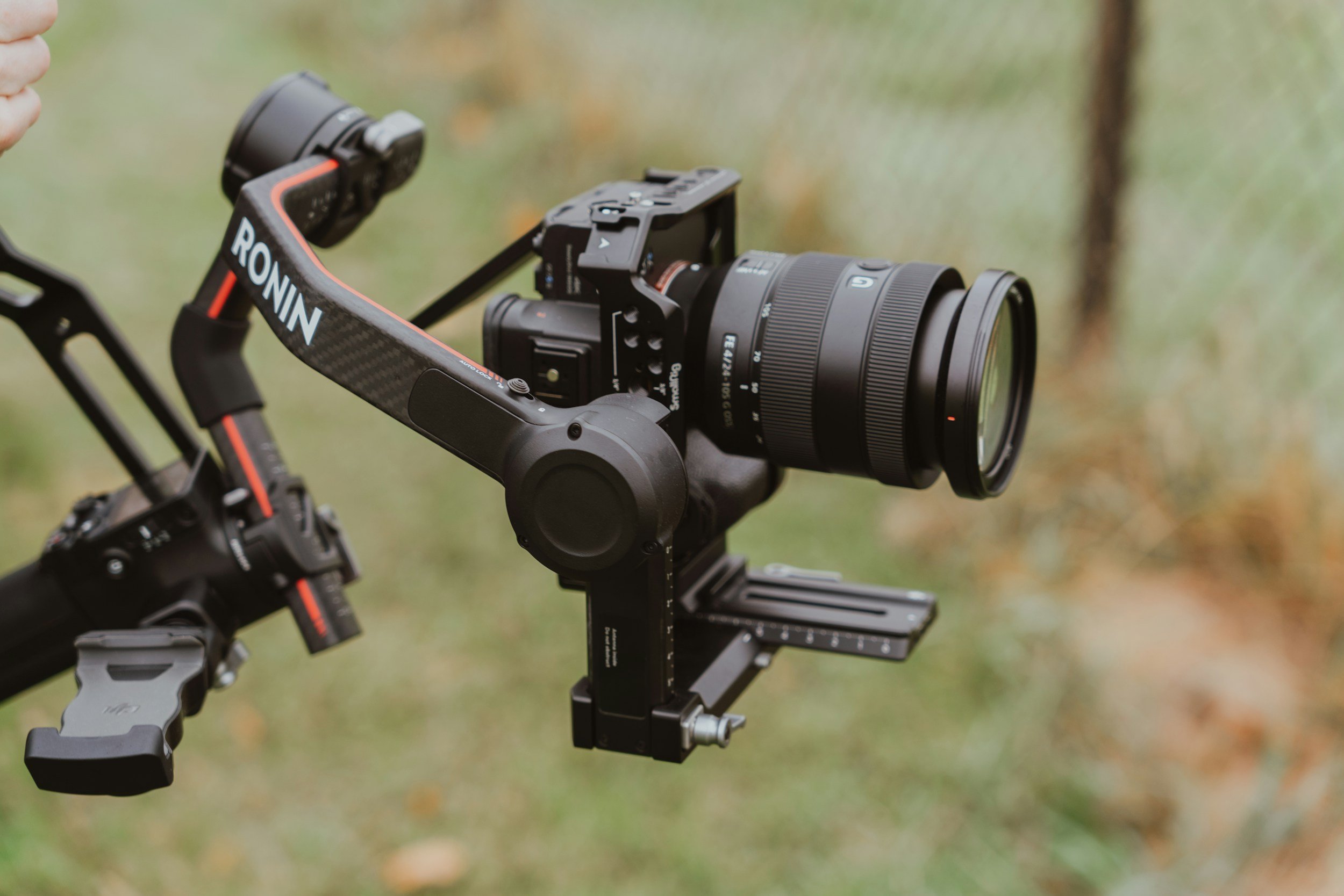Professionele camera op een Steadicam camera stabilisatiesysteem, klaar voor opname, met een groene, licht vervaagde achtergrond.