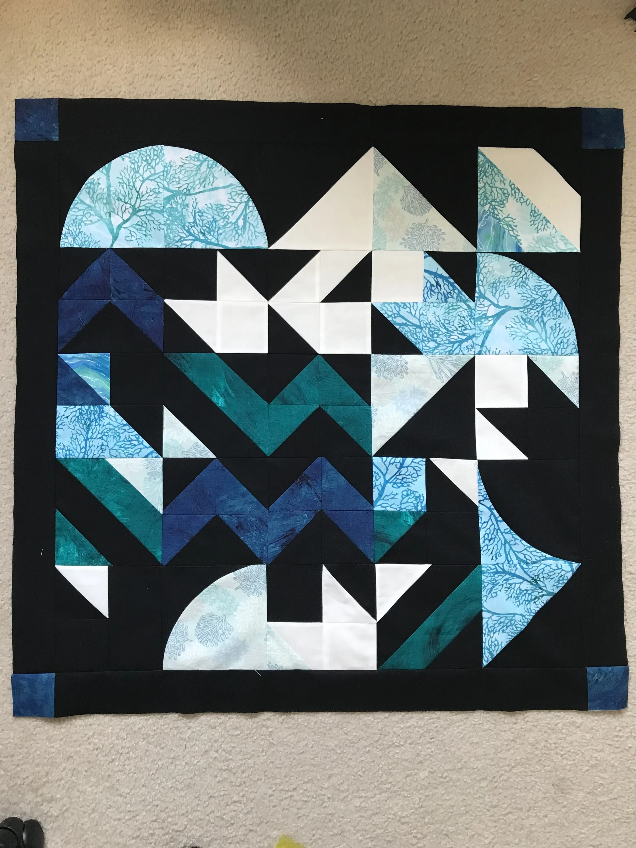 randomly pieced wall quilt of blue and black colors