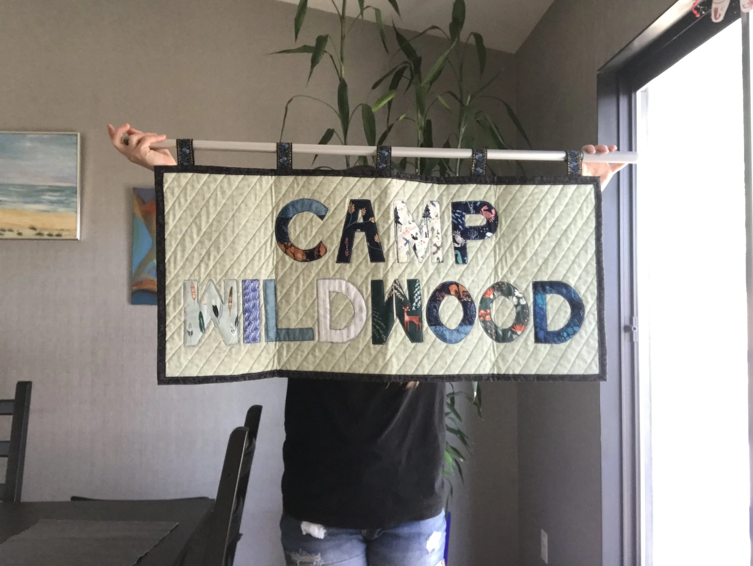 camp wildwood sign made out of fabrics with nature patterns