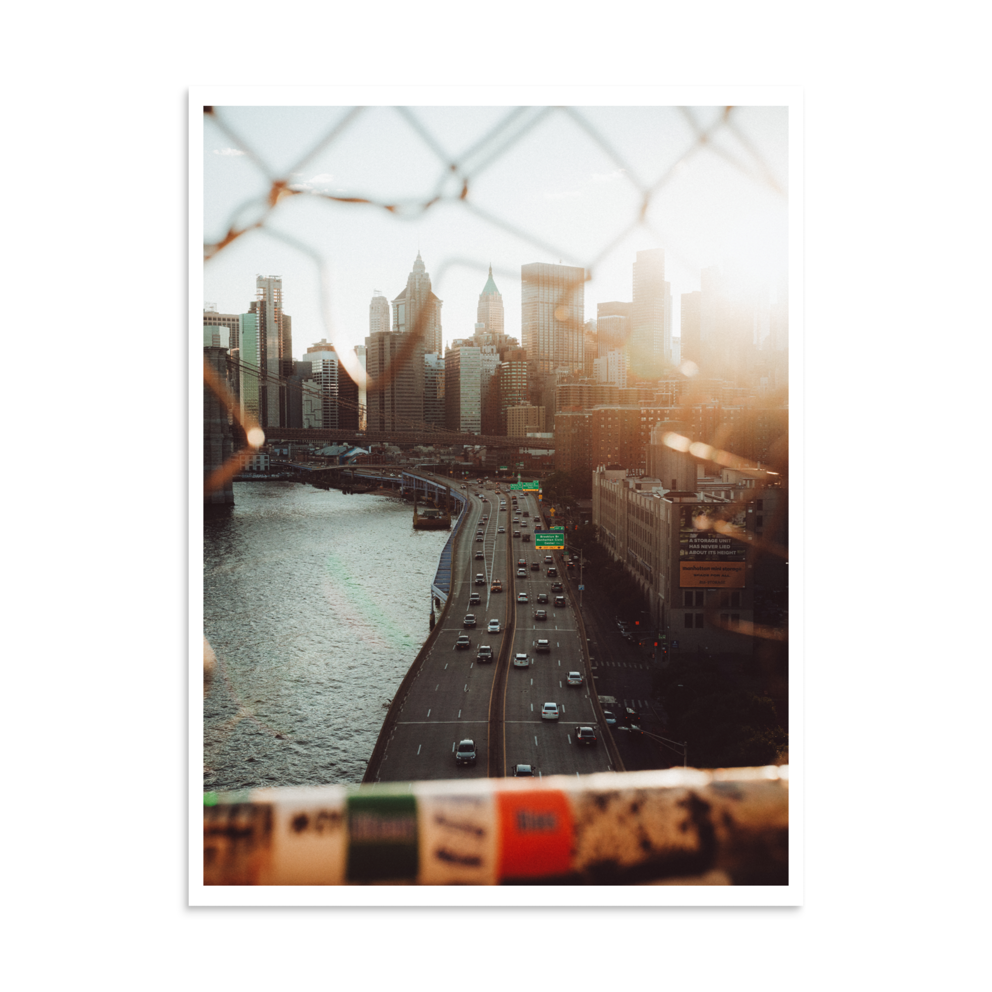 Highway beside the East River leading toward the Lower Manhattan skyline in warm evening sunlight.