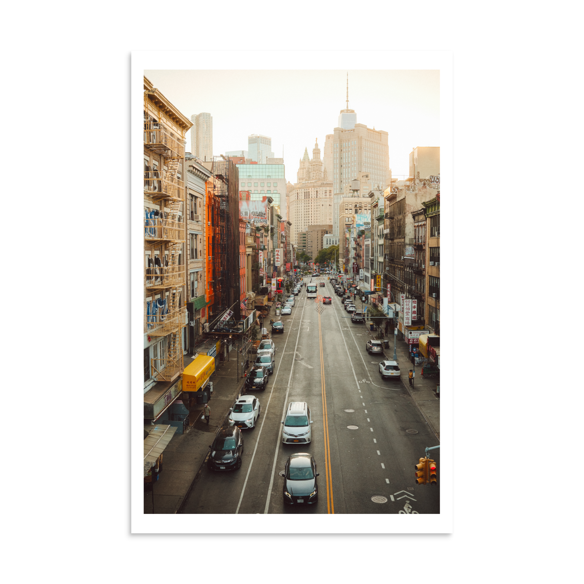 Elevated street view through Chinatown in New York with traffic, fire escapes and Lower Manhattan architecture.