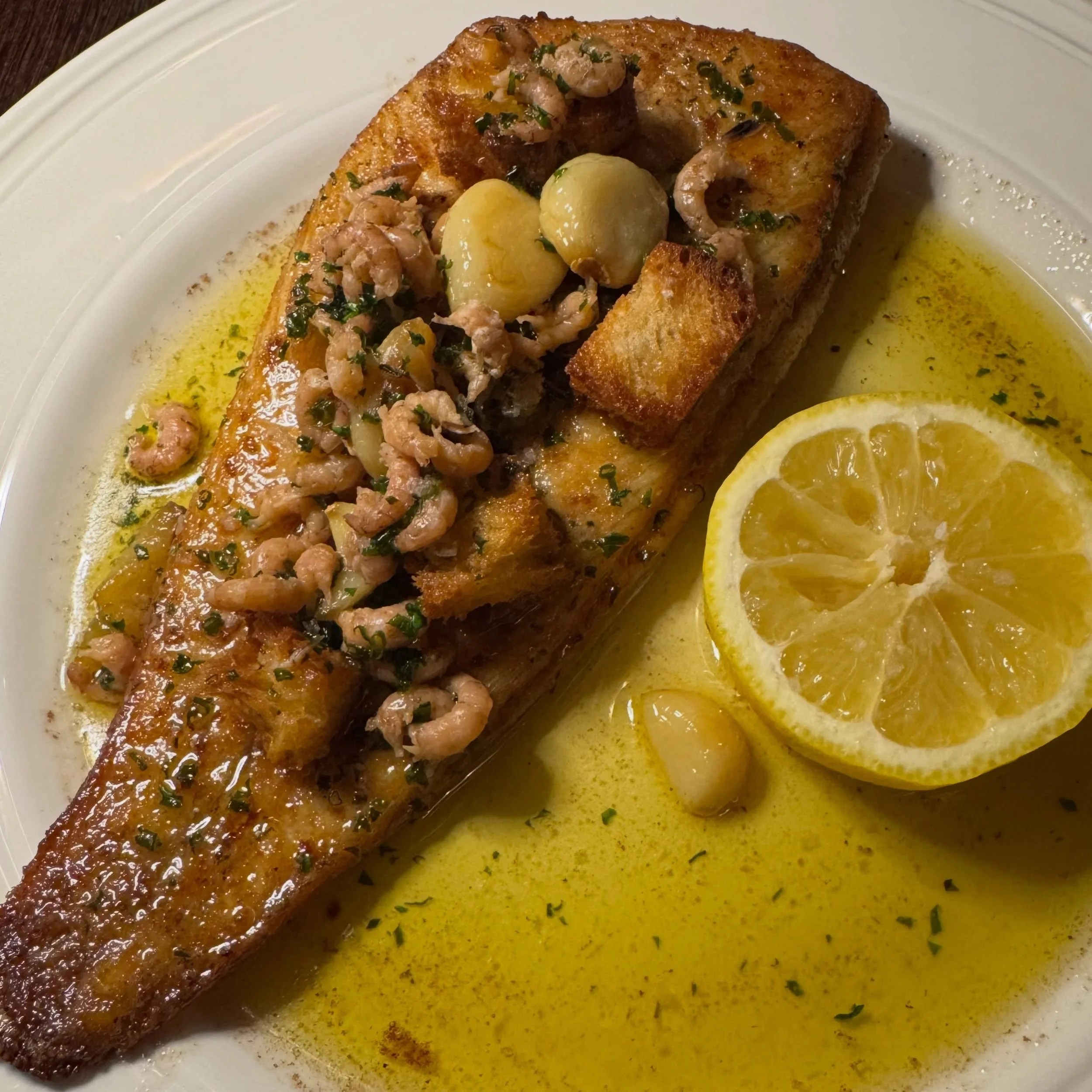 Dover sole, drowned in garlic butter a major if you know, you know.

Delicate, rich and full of flavour, served with shrimp, crisp croutons and slow-cooked garlic. One of the finest seasonal fish on the market, served the Court way. Open 12:00 til&rs