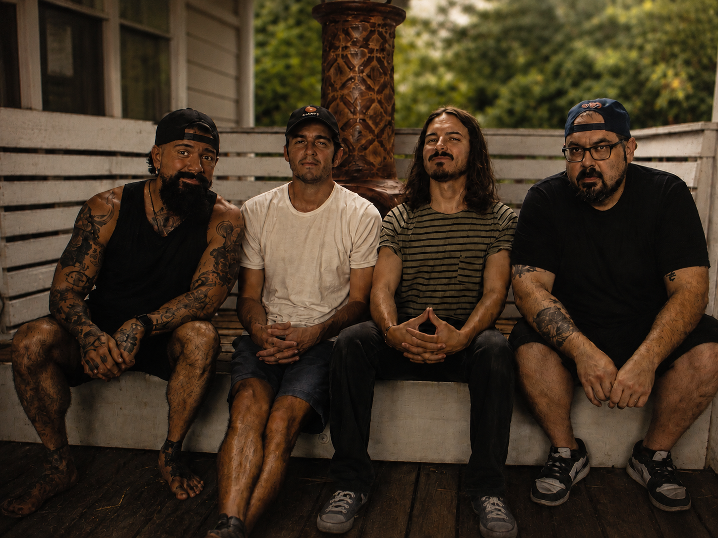 Four members of Strange Trip, an Orlando, Florida psychedelic groove rock band, seated together outdoors.