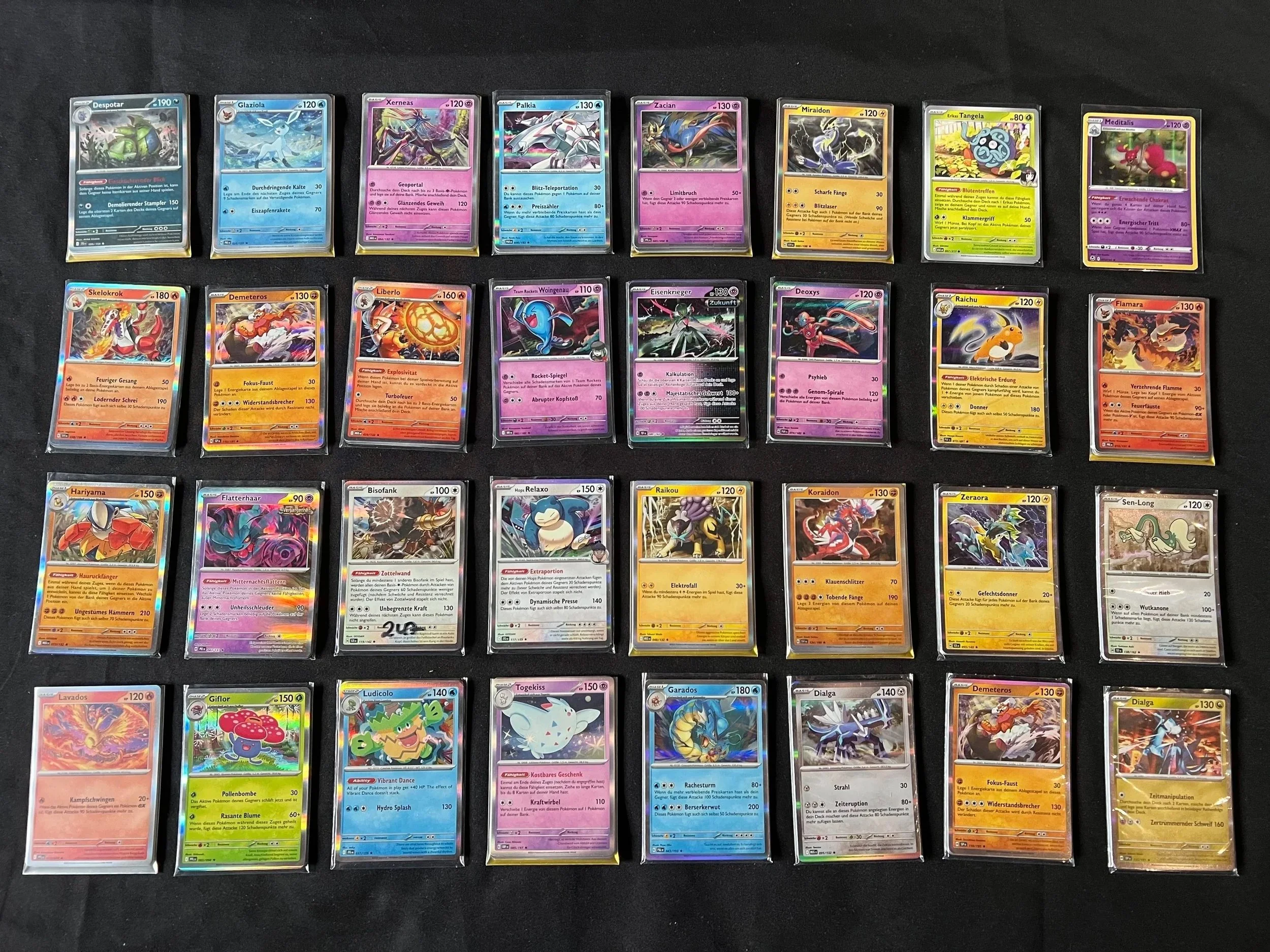 Pokemon Sammelkarten auf schwarzem Hintergrund, geordnet in Reihen.