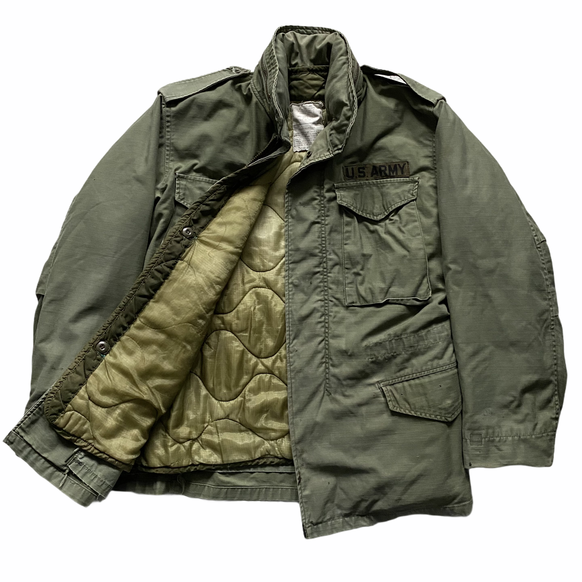 U.S. Army military jacket with patches on the chest, lying flat on a white background.