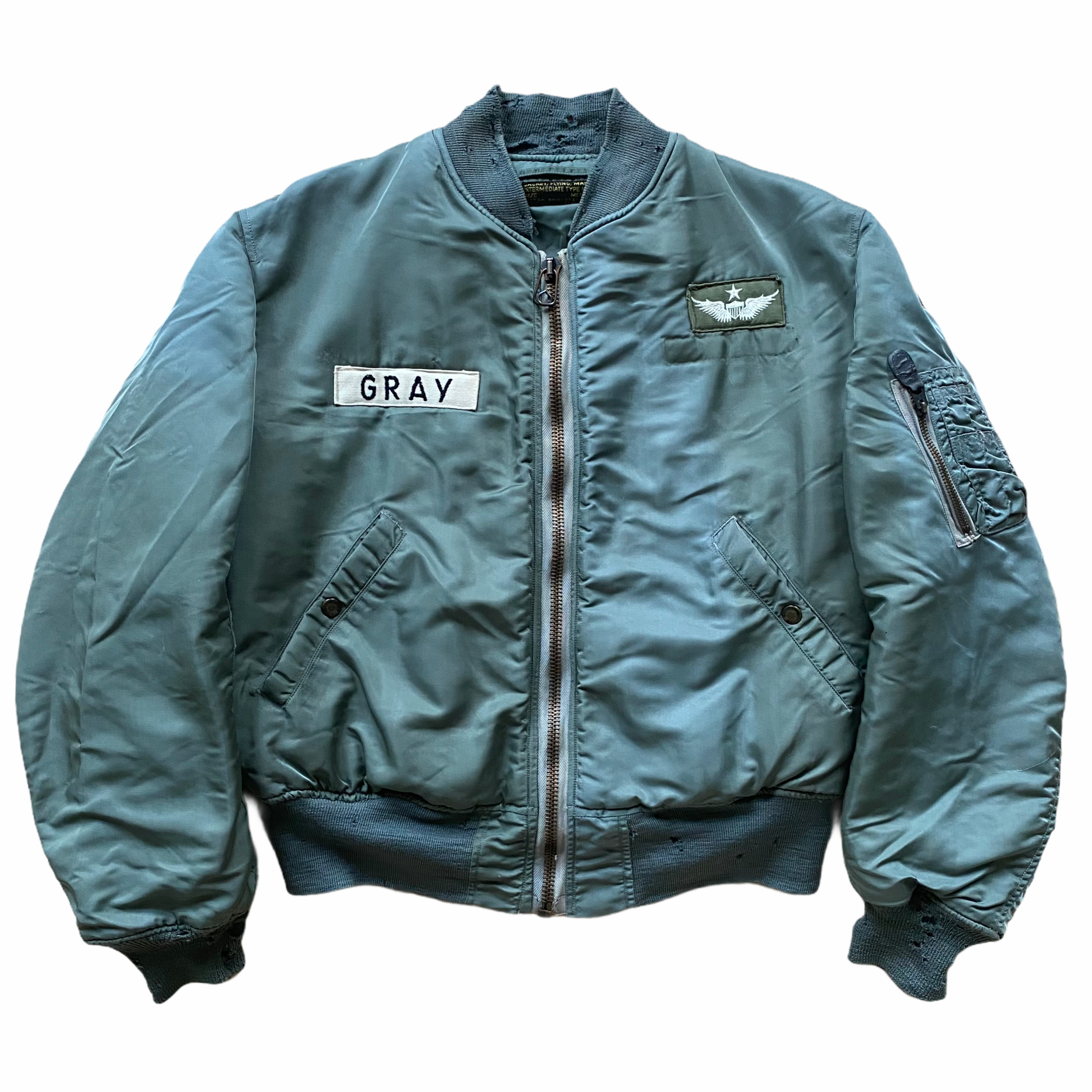 A black bomber jacket with patches, including one with the name 'GRAY' and an eagle emblem, set against a white background.