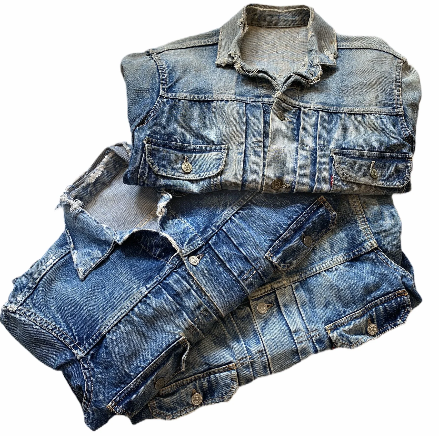 A collection of blue denim jackets and jeans, with some jackets displayed on a mannequin torso and jeans folded on top of each other.