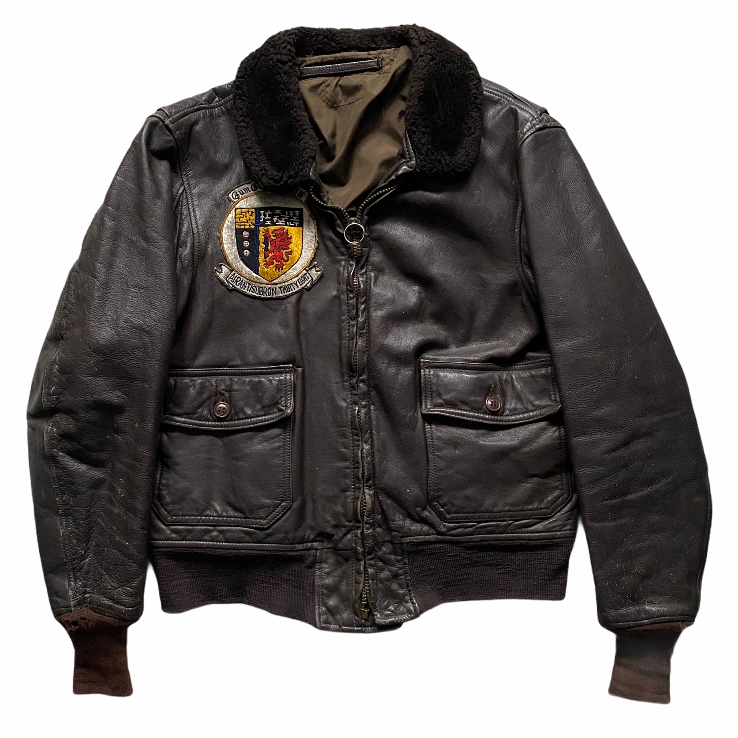 Leather bomber jacket with patches, brown collar, and zip closure, displayed with arms outstretched.