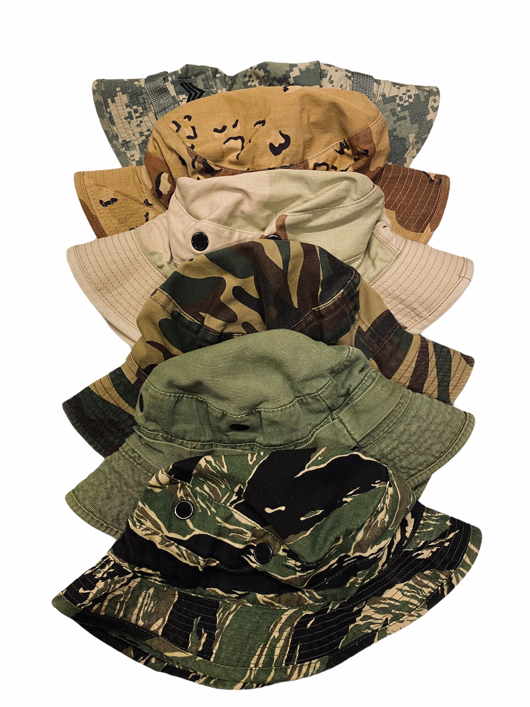 Stack of seven camouflage and tan military-style hats arranged vertically.