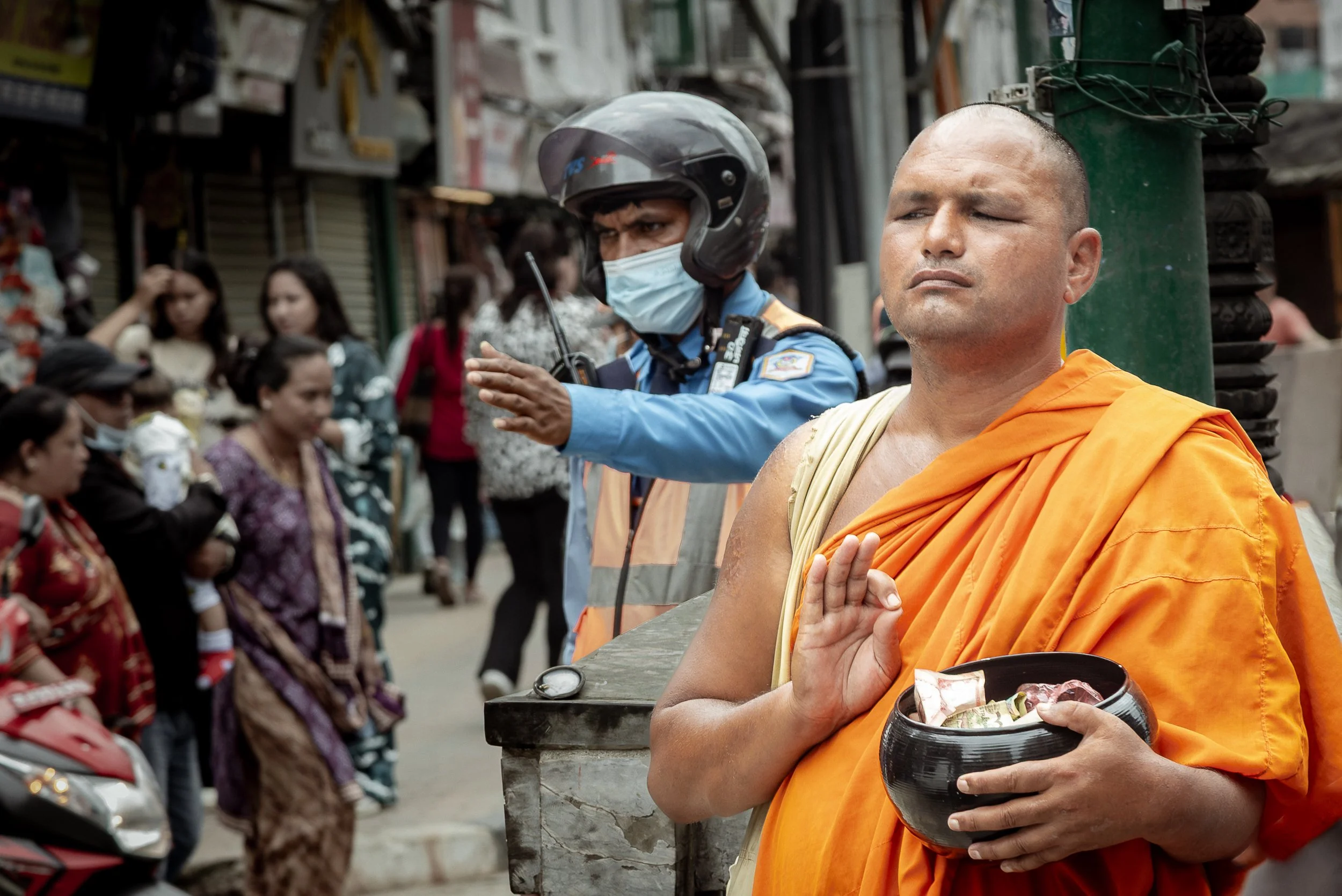 Two raised hands on the same street. Only one of them stops traffic. Kathmandu, 2025.