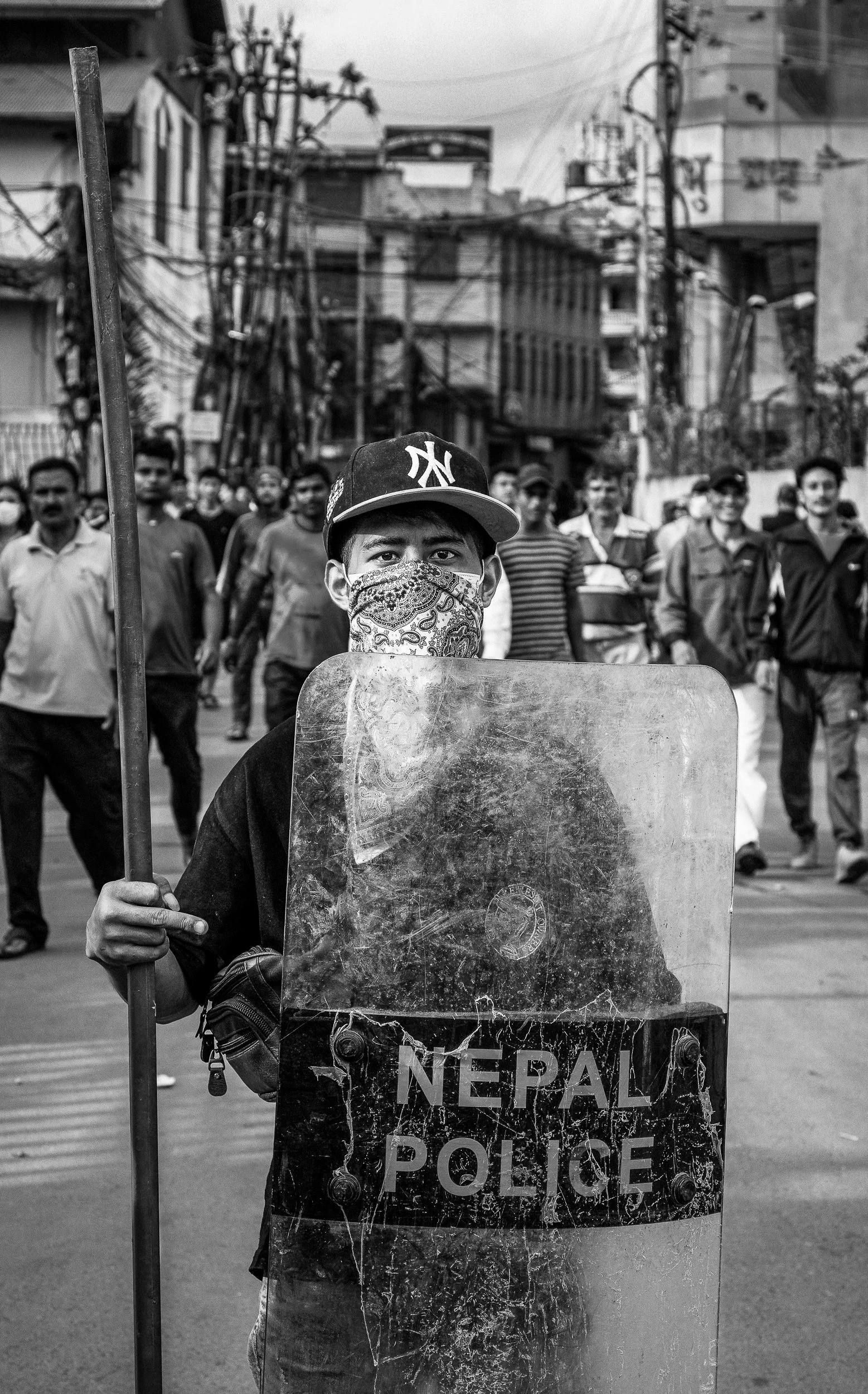 Protester displaying Nepal police shield stolen from police station.